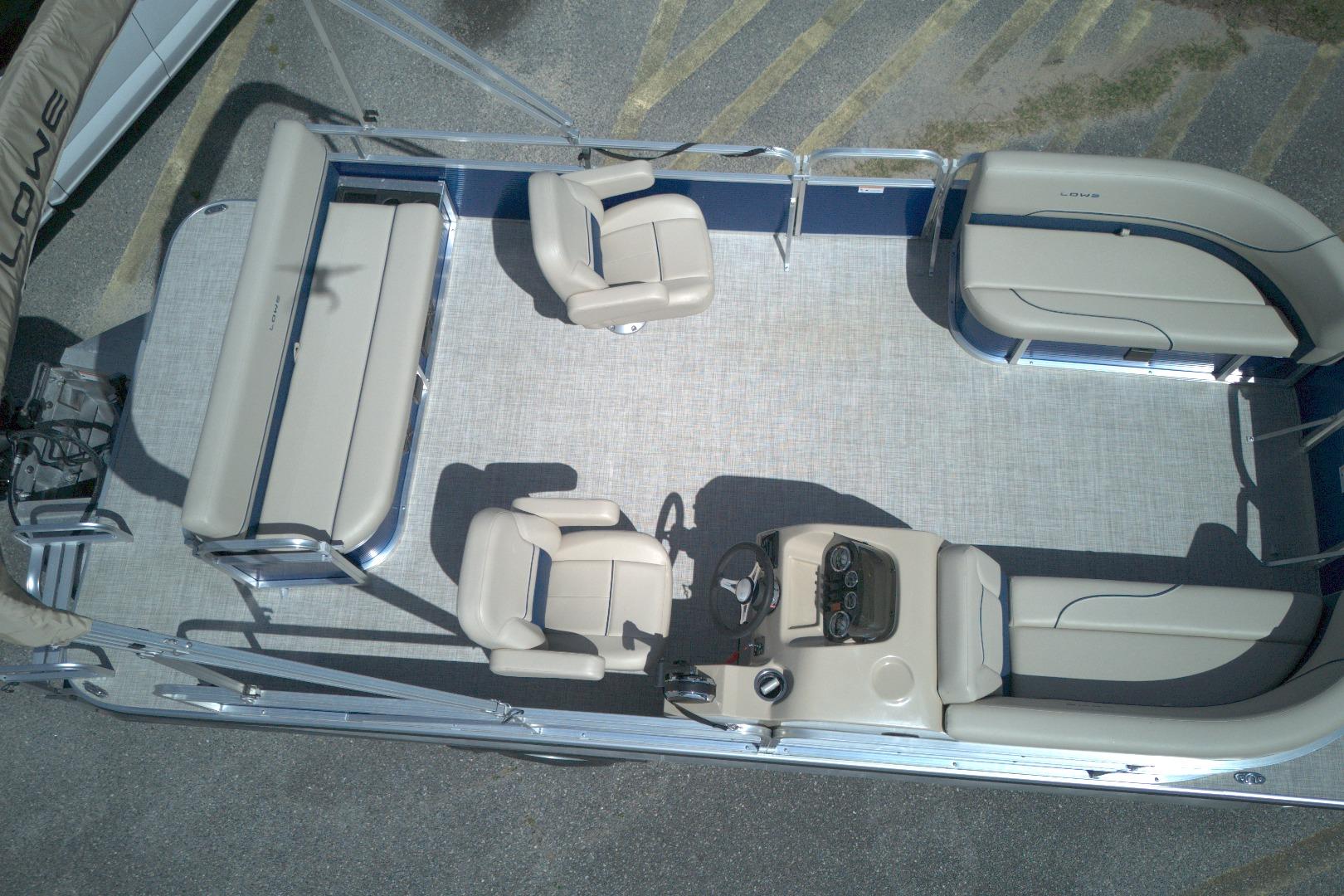 2024 Lowe Ultra 200 Cruise pontoon boat interior with beige seating and steering console.