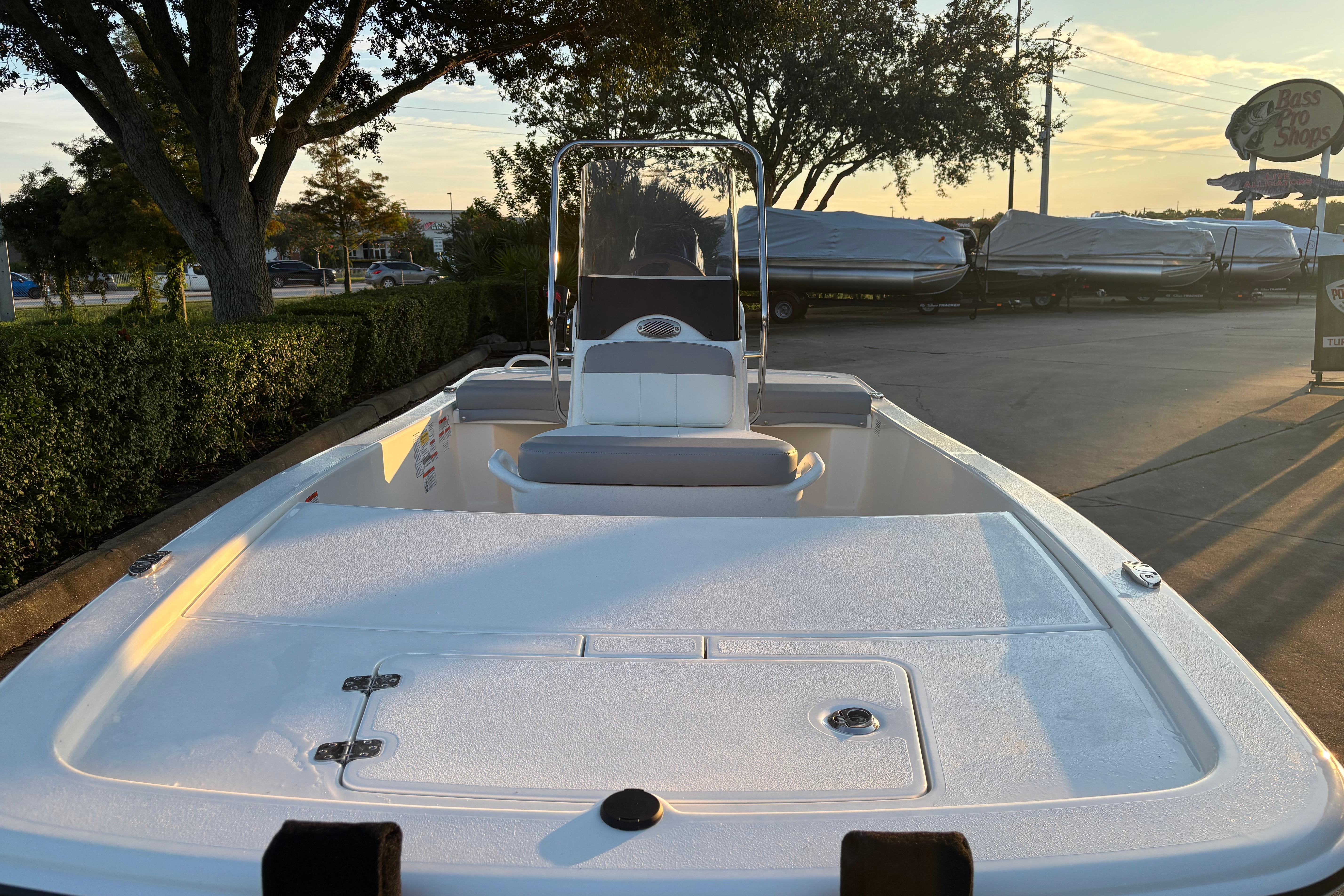 2026 Mako Pro Skiff 13 CC boat, white interior, parked outdoors at sunset.