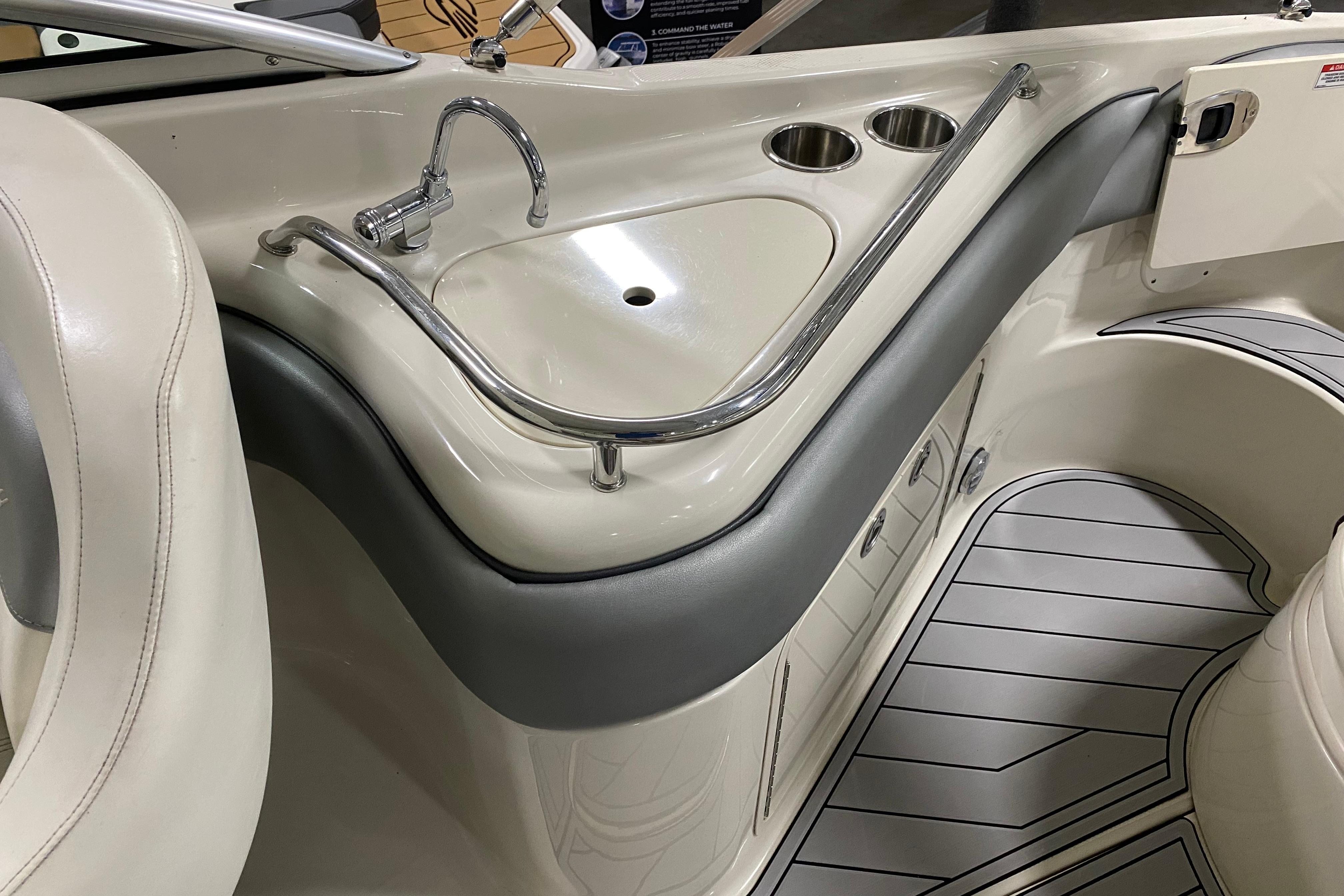 Interior of 2008 Sea Ray 240 Sundeck featuring a sleek sink and cup holders.