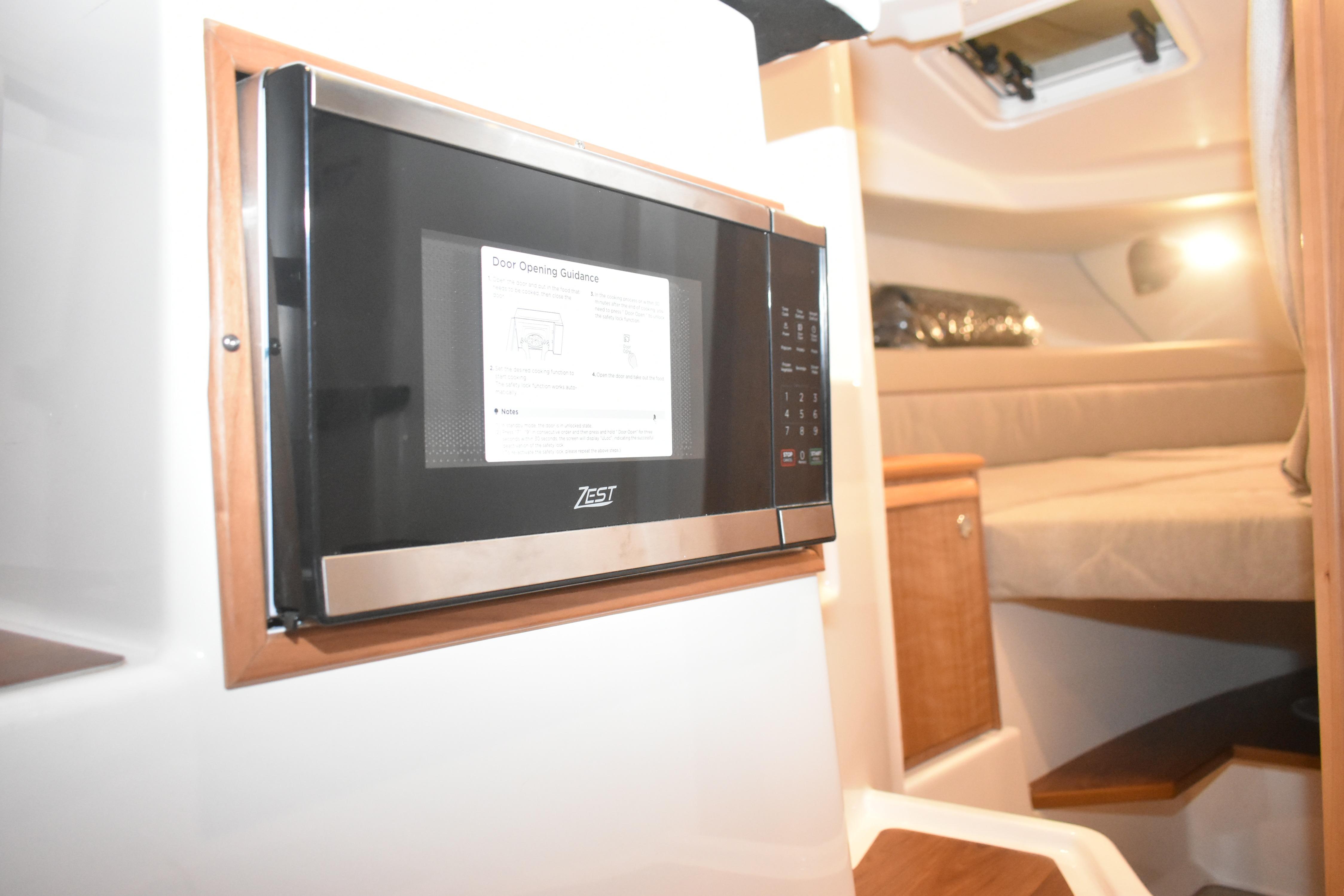 2026 Cutwater C-248 Coupe interior with microwave and cozy cabin bed.