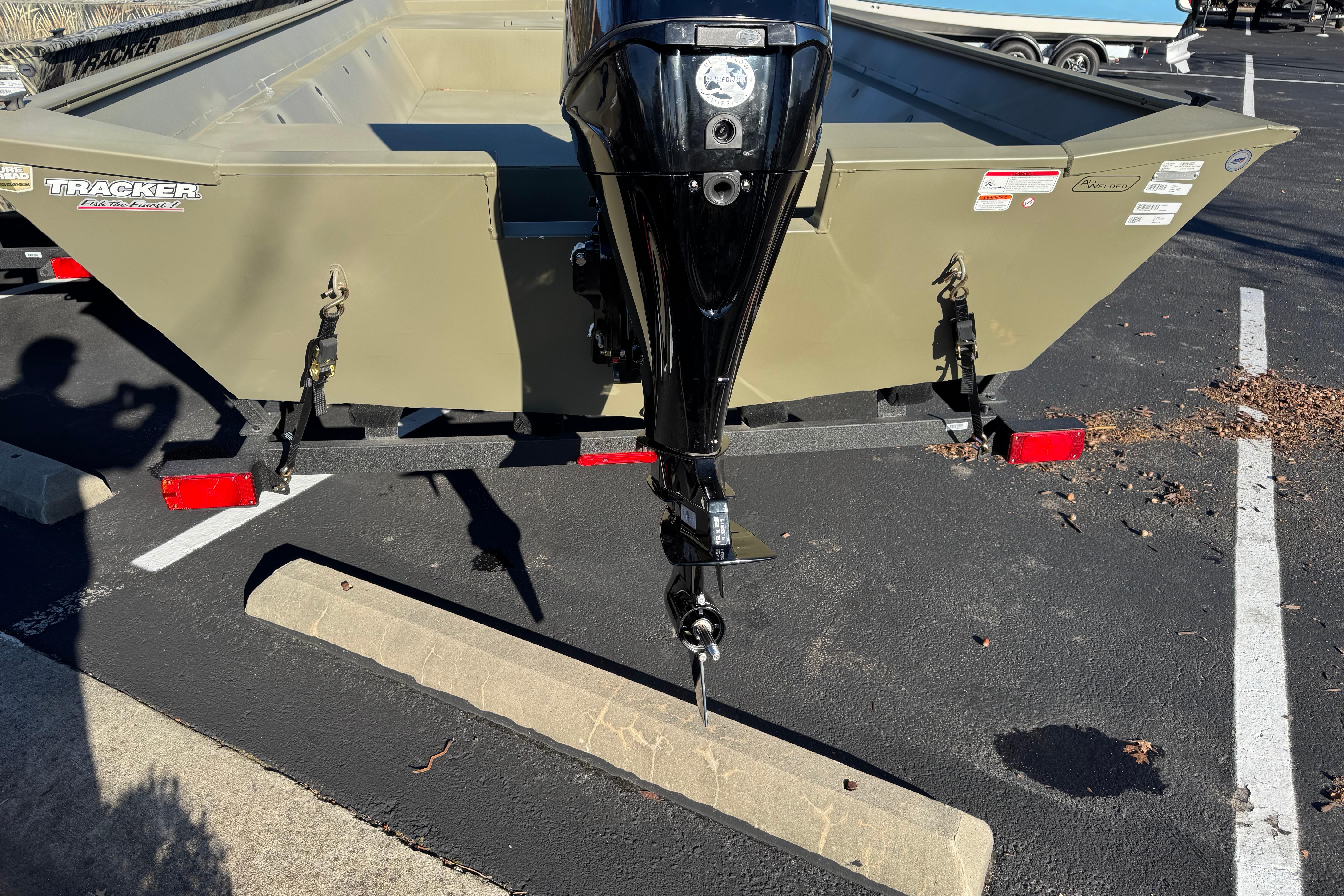 2026 Tracker Grizzly 2072 Utility boat with outboard motor in parking lot.