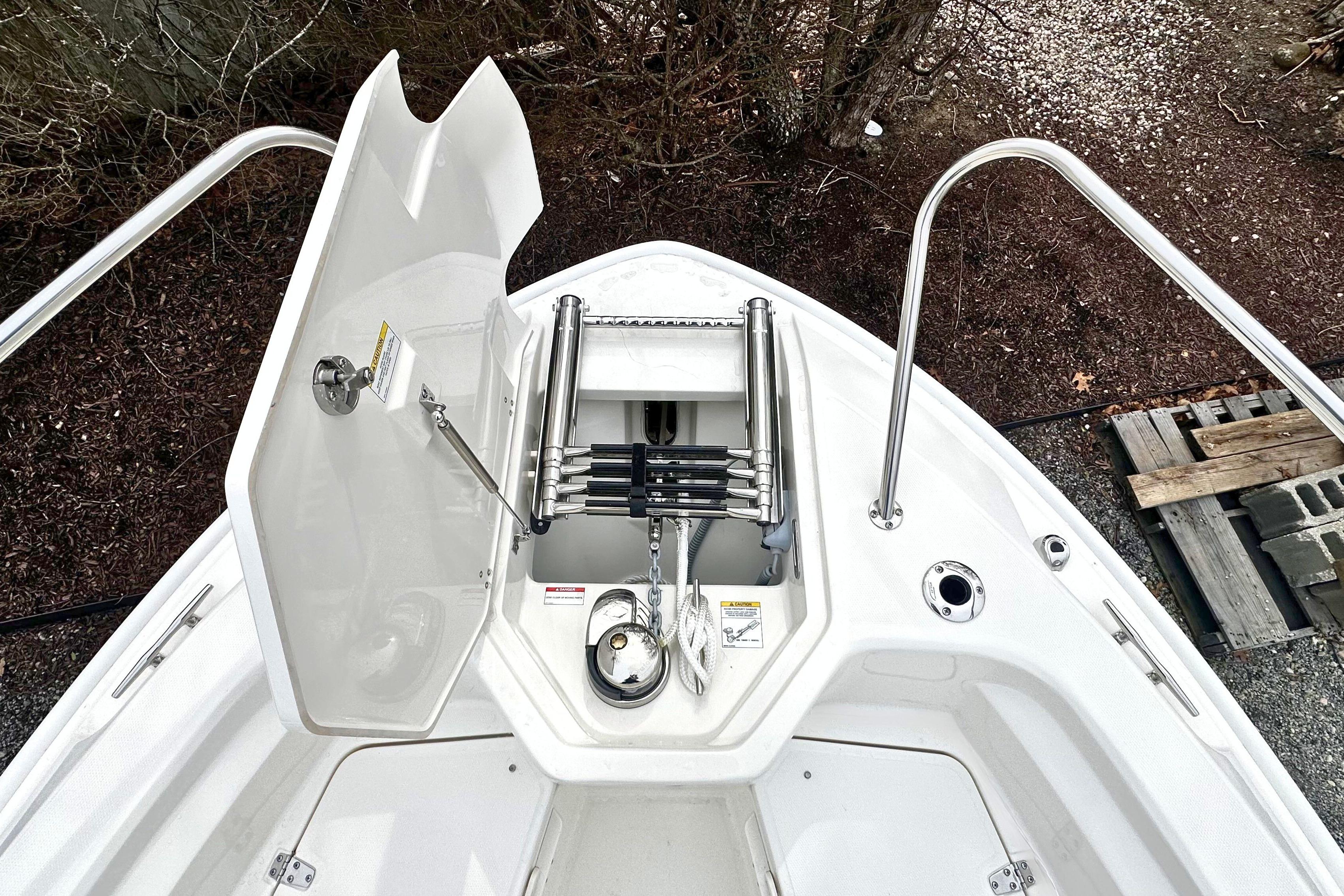 2026 Boston Whaler 280 Dauntless bow storage compartment with ladder and anchor.