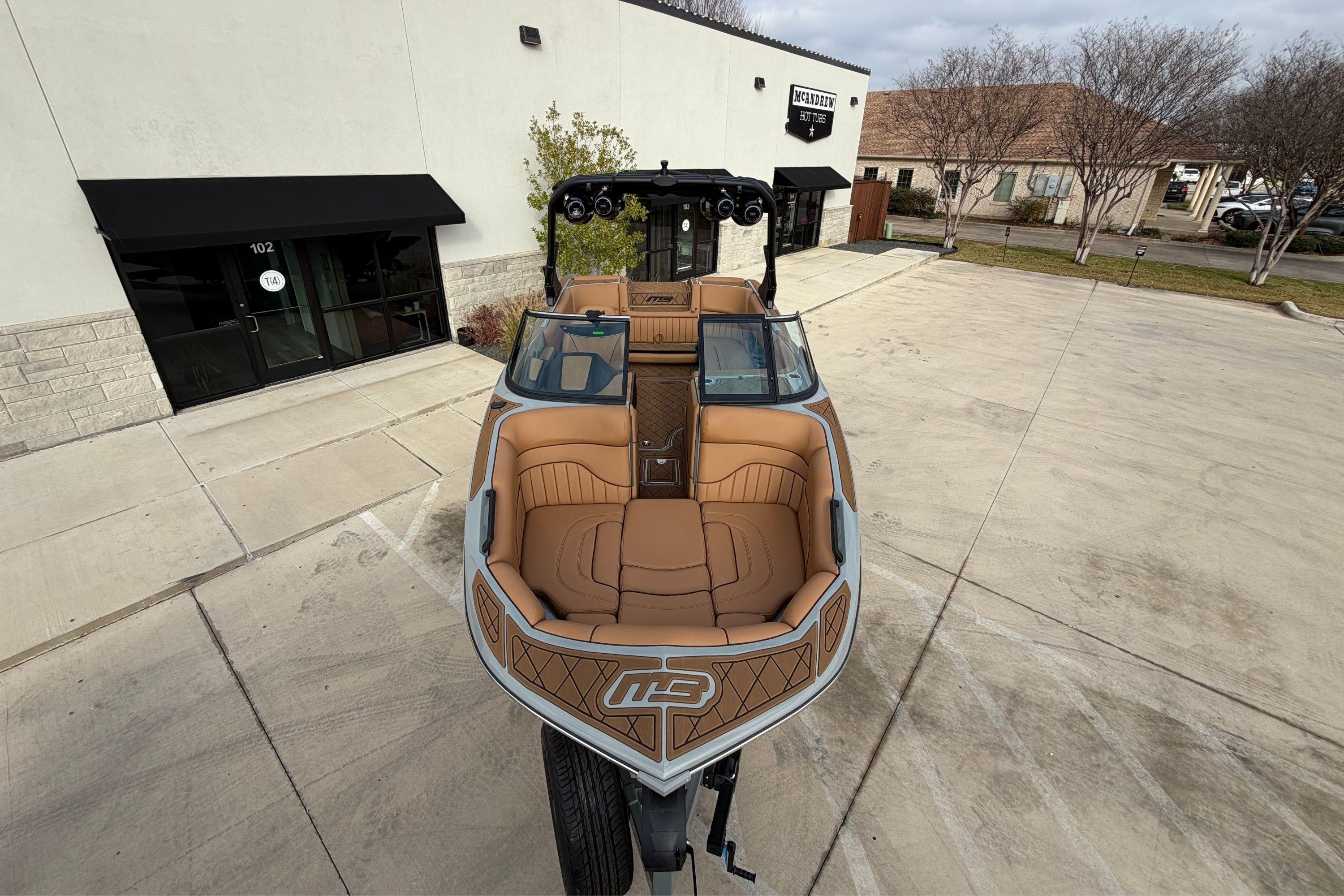 2026 MB B52 21 Alpha boat with tan interior, parked outside a building.