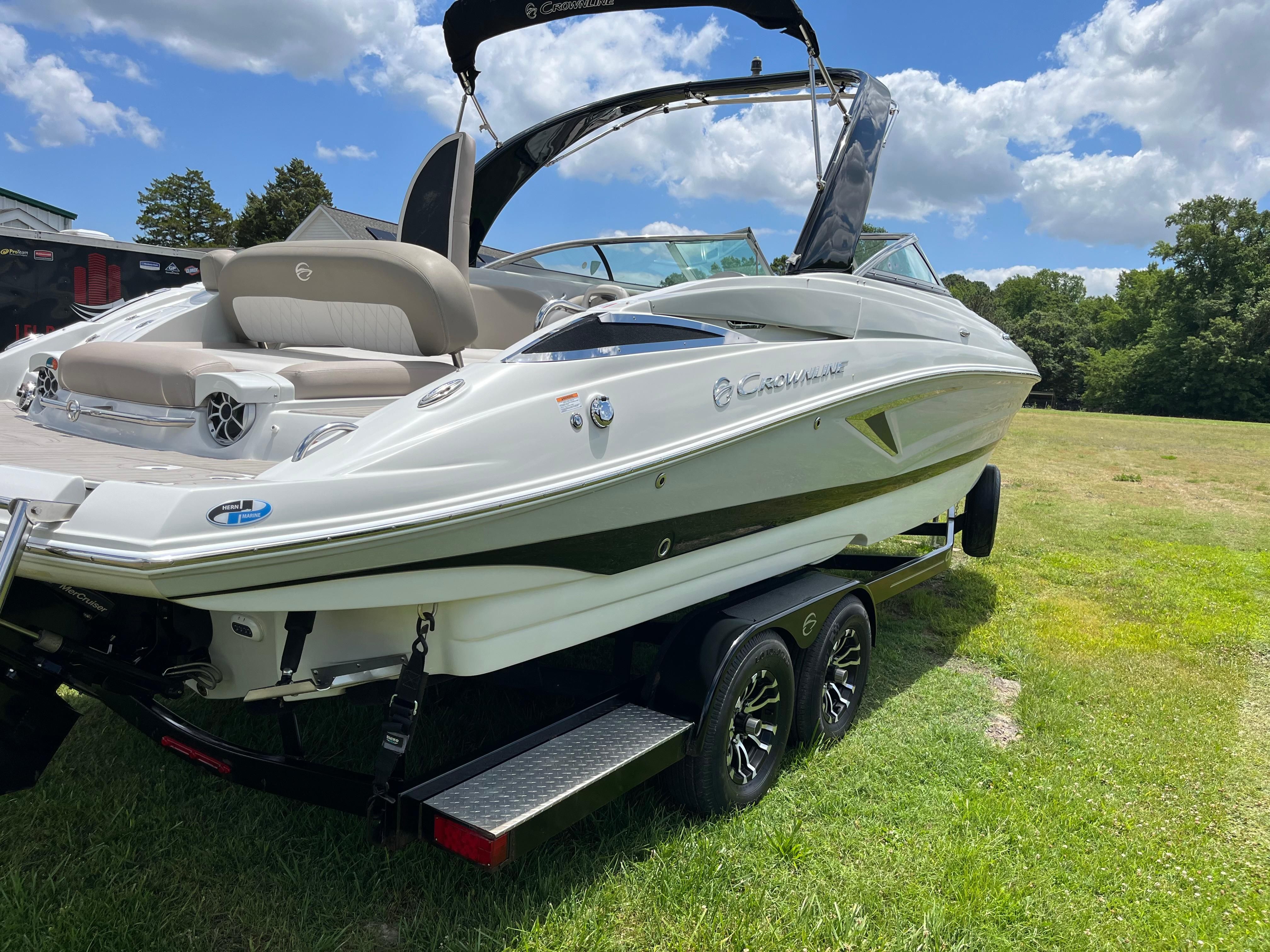 A 2019 Crownline E 285 boat on a trailer in a grassy area.