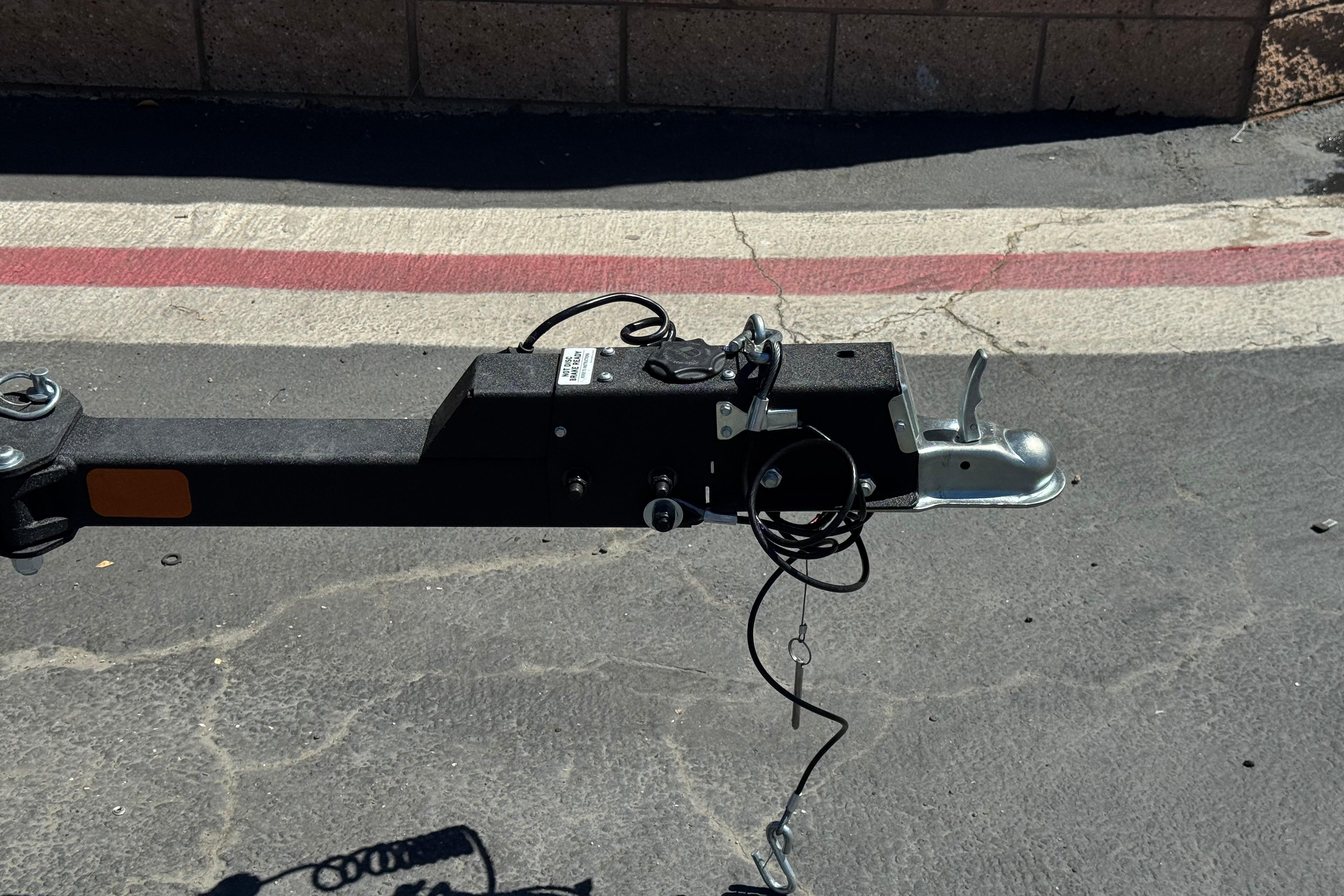 Trailer hitch of a 2025 Tracker Pro Team 175 TXW on pavement background.