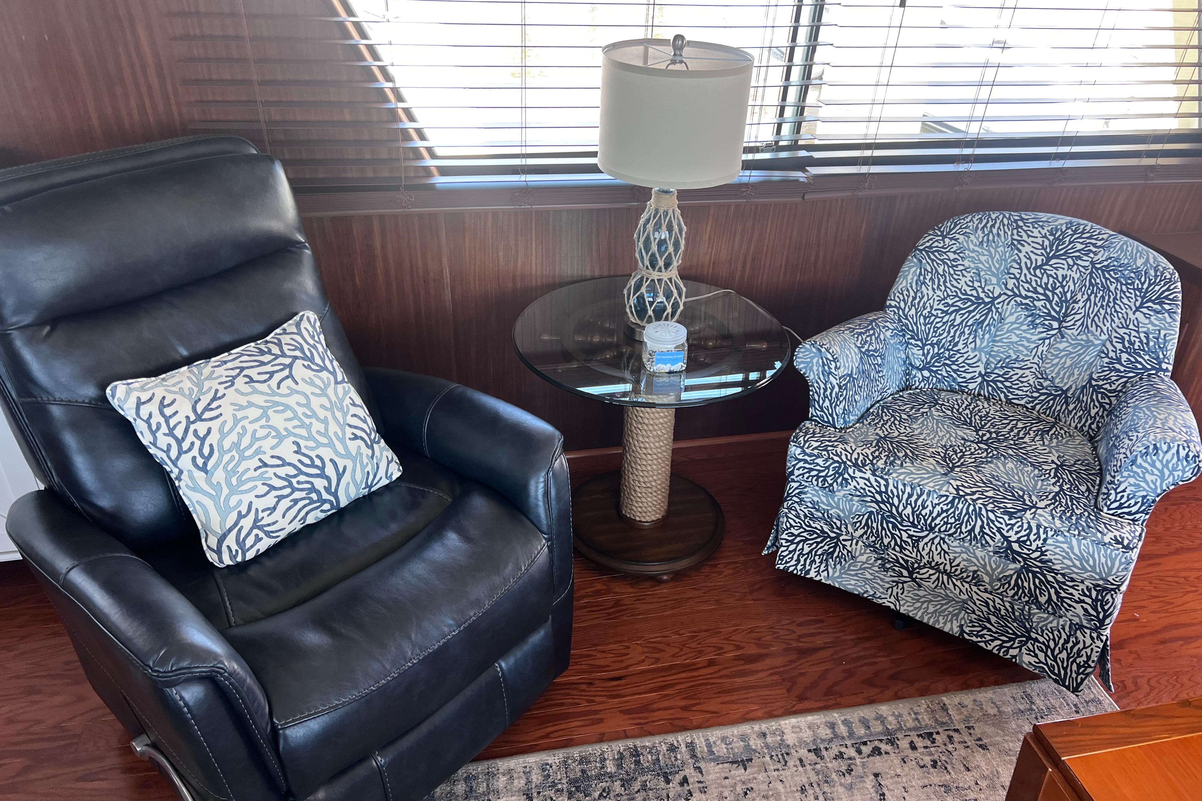 Cozy seating area on 1987 Hatteras 70 Cockpit Motor Yacht with stylish chairs and table.