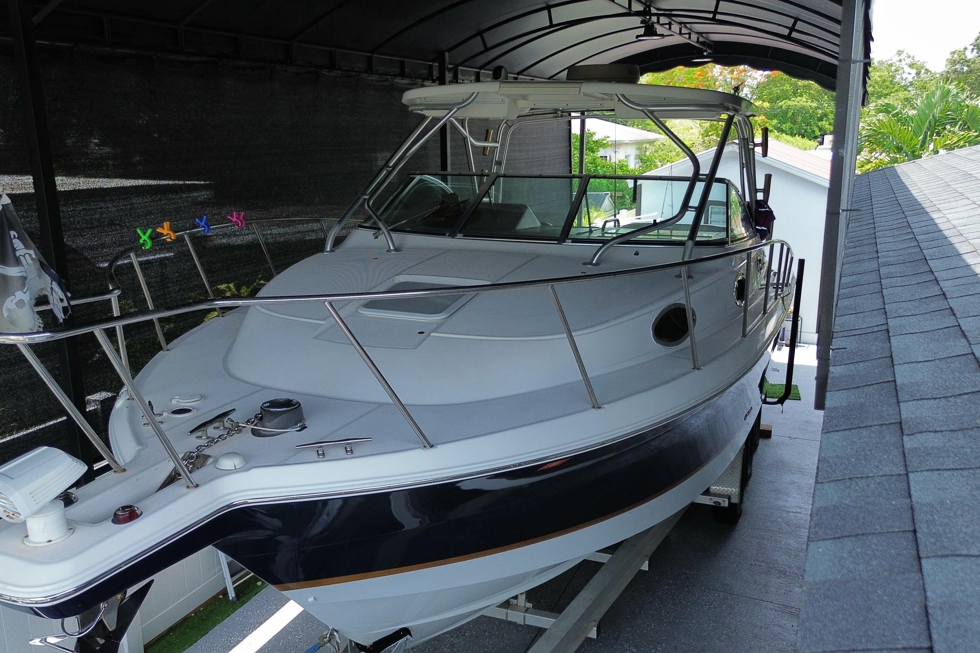2005 Wellcraft 290 Coastal boat under a covered dock, showcasing sleek design and sturdy build.