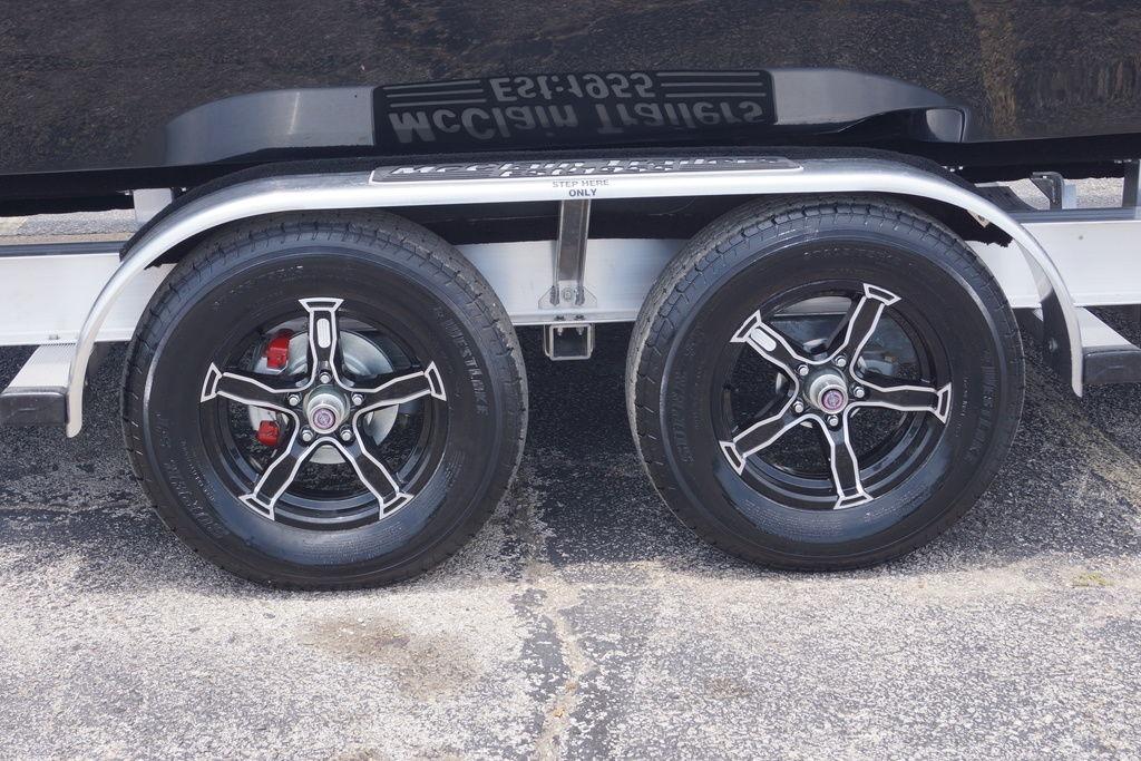 Trailer wheels of a 2027 Tidewater 2500 Carolina Bay boat on pavement.