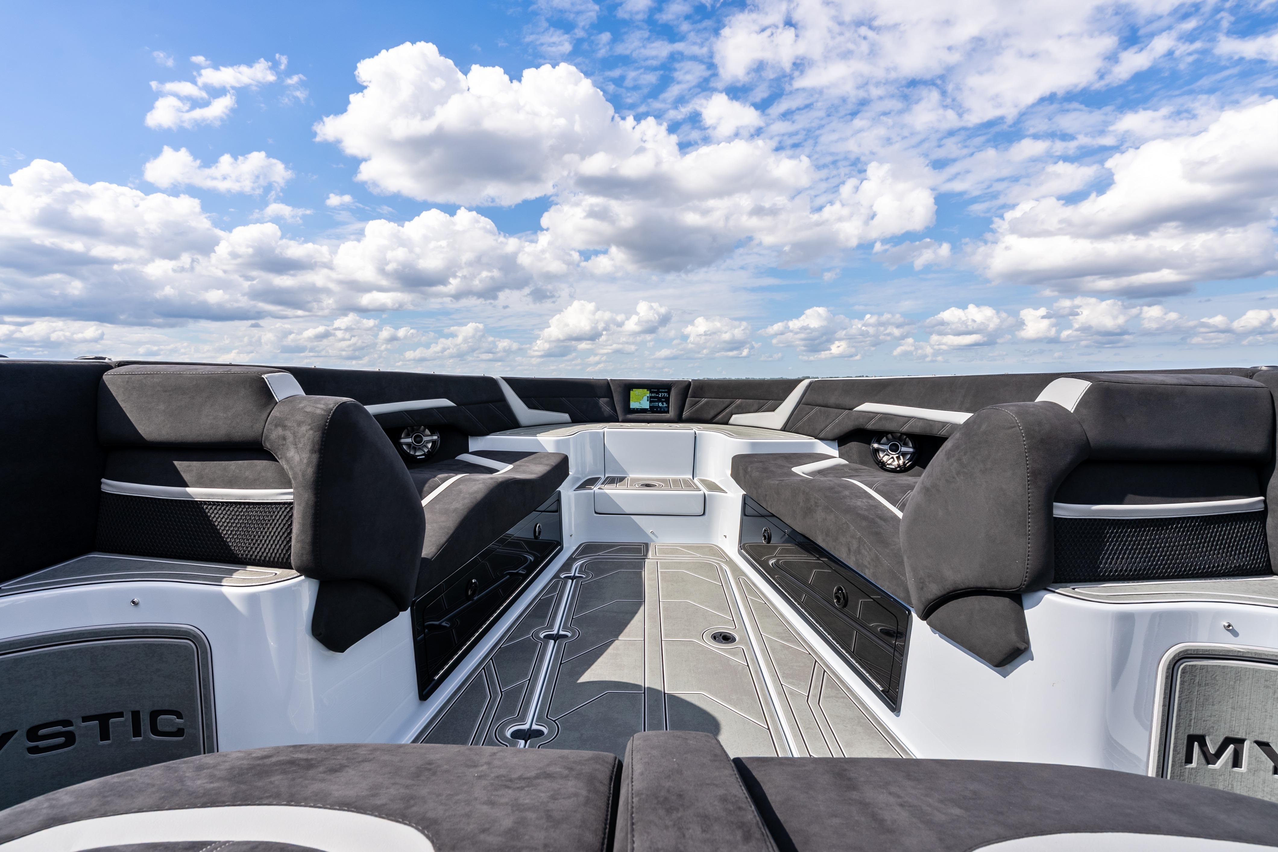 2027 Mystic Powerboats M4200 interior with luxurious seating under a vibrant blue sky.