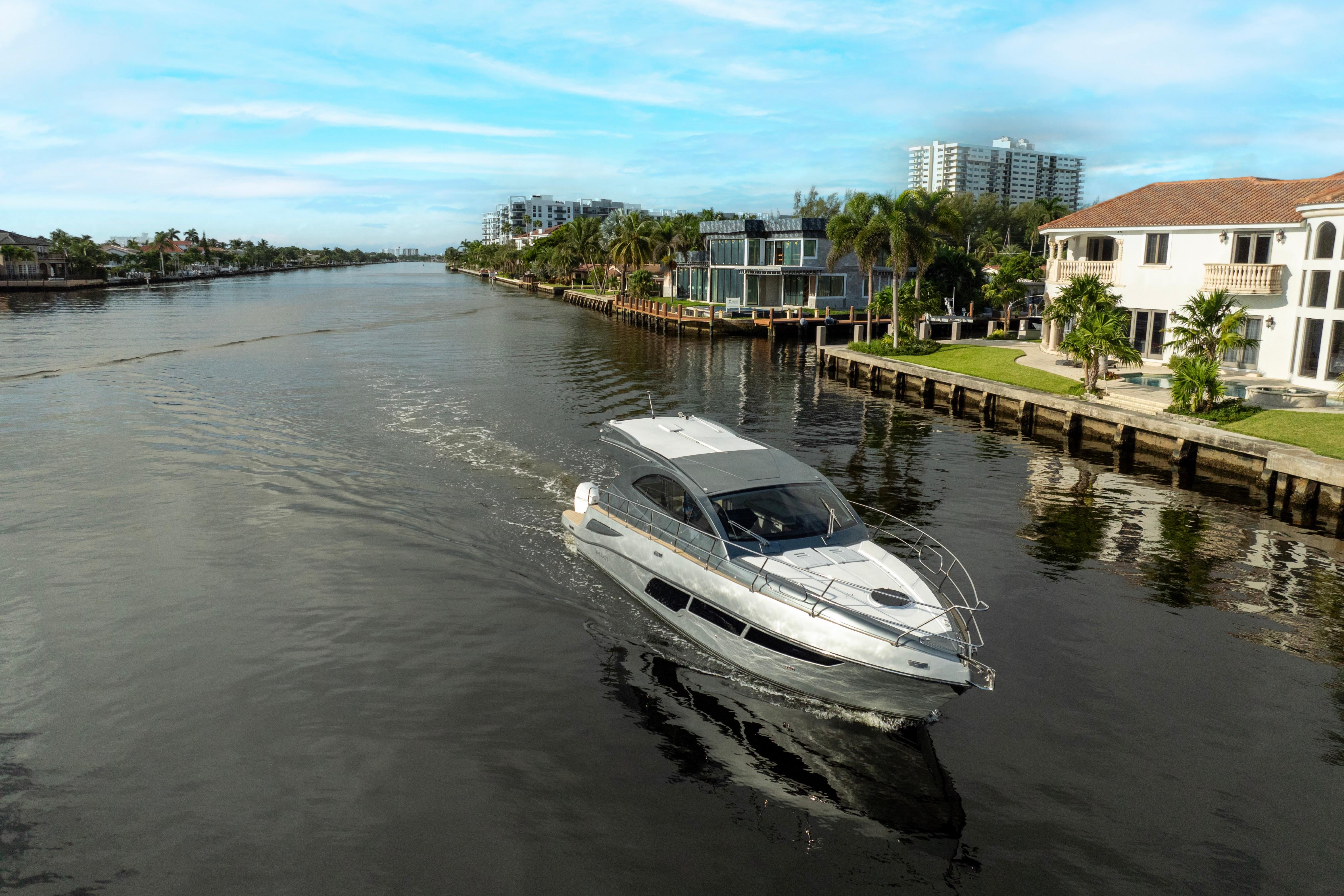 2025 Valiatt 410HT luxury yacht cruising along a scenic waterfront.