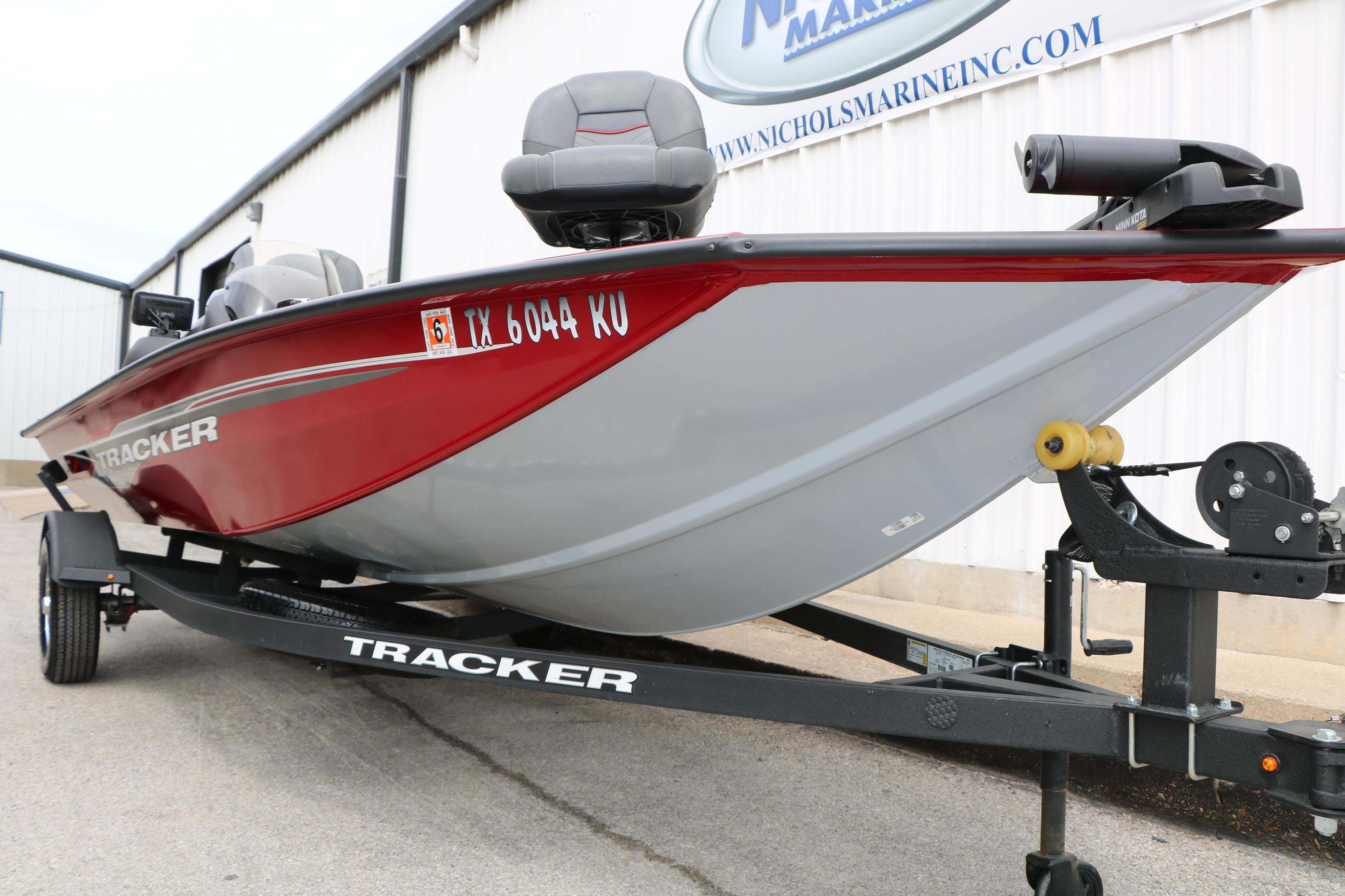 2024 Tracker Pro Team 175 boat on trailer, red and gray design, parked outdoors.