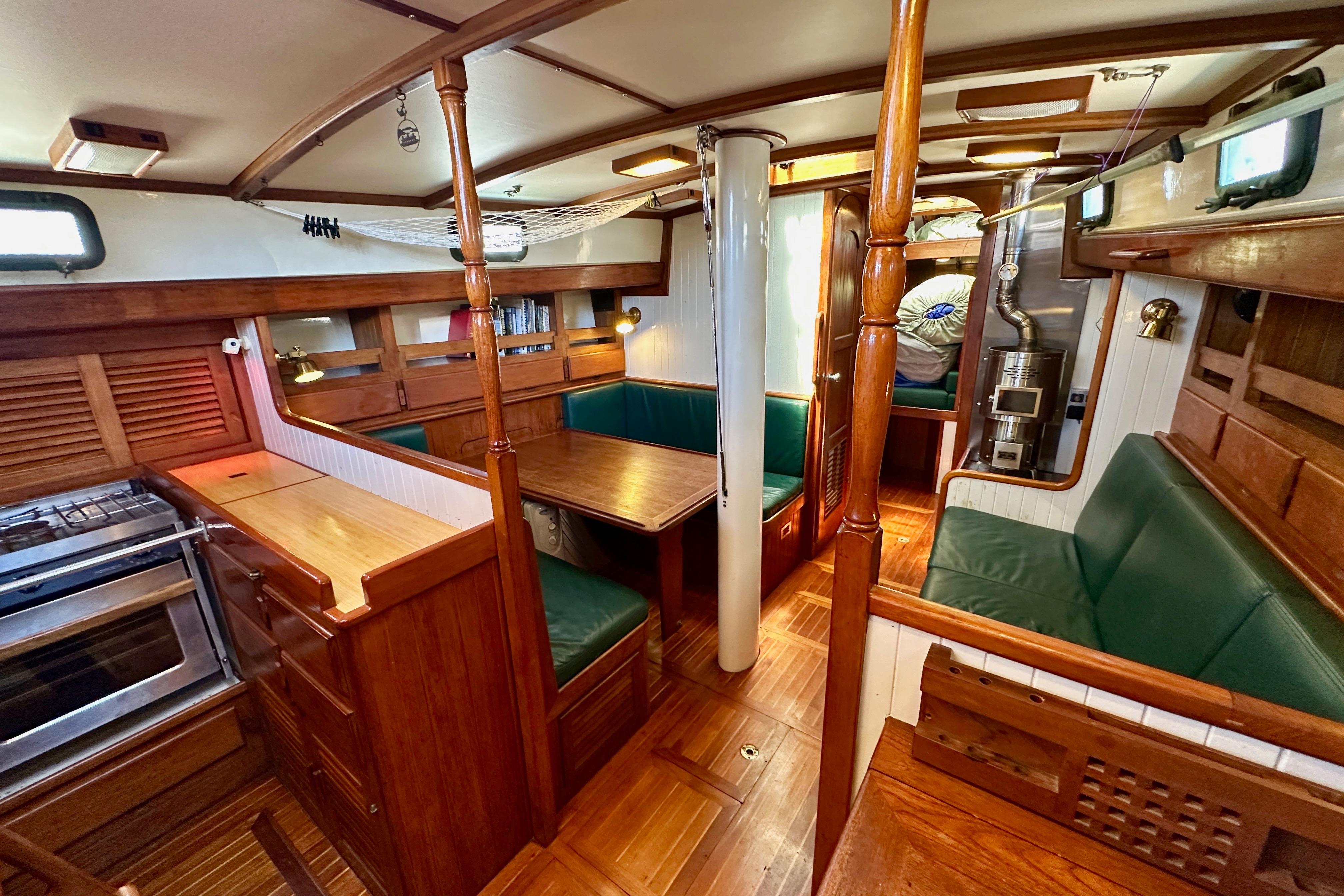 Interior of a 1981 Kelly Peterson 46 sailboat with wood finishes and green seating.