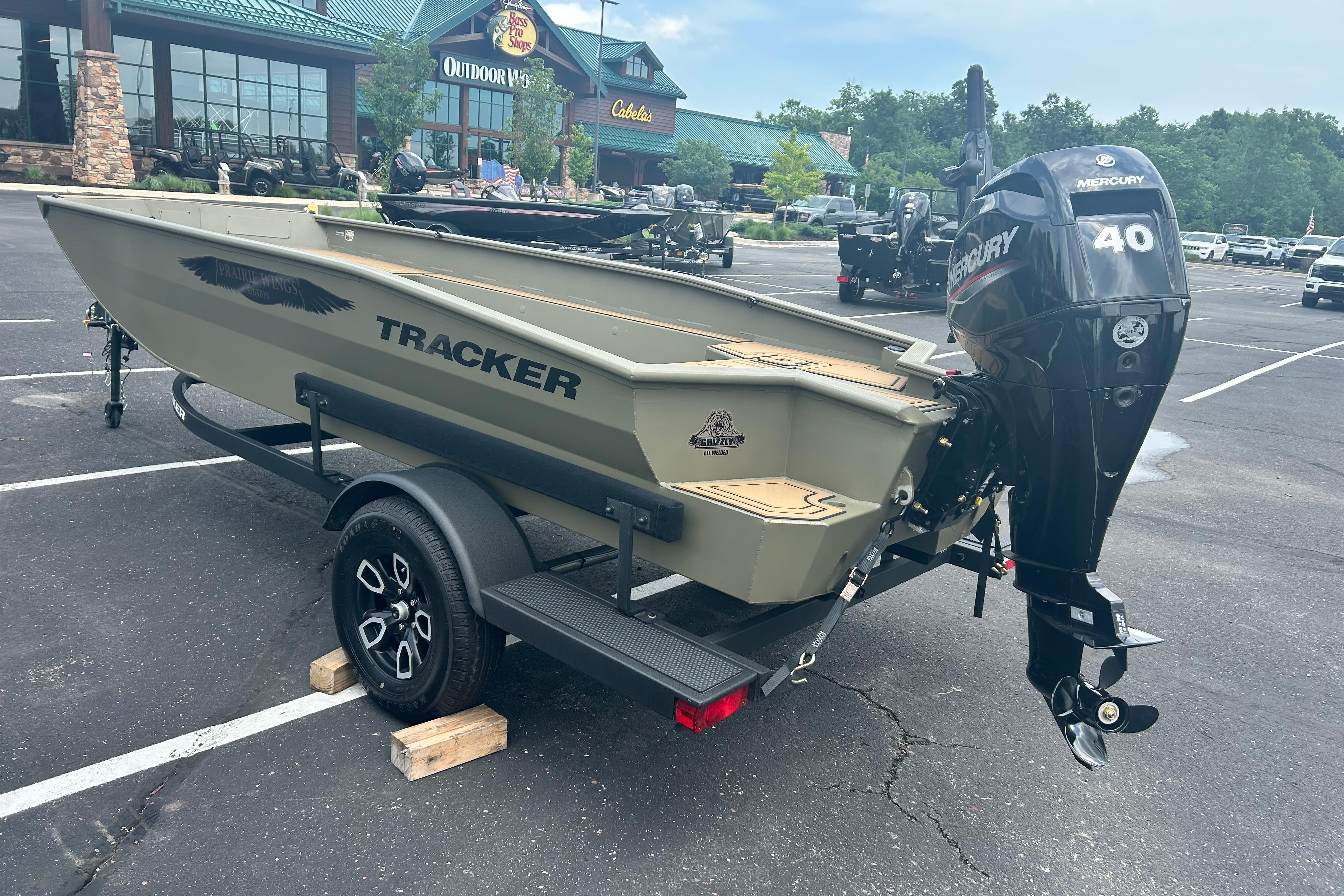 2026 Tracker Grizzly 1650 T Prairie Wings Edition boat with Mercury 40 engine in parking lot.