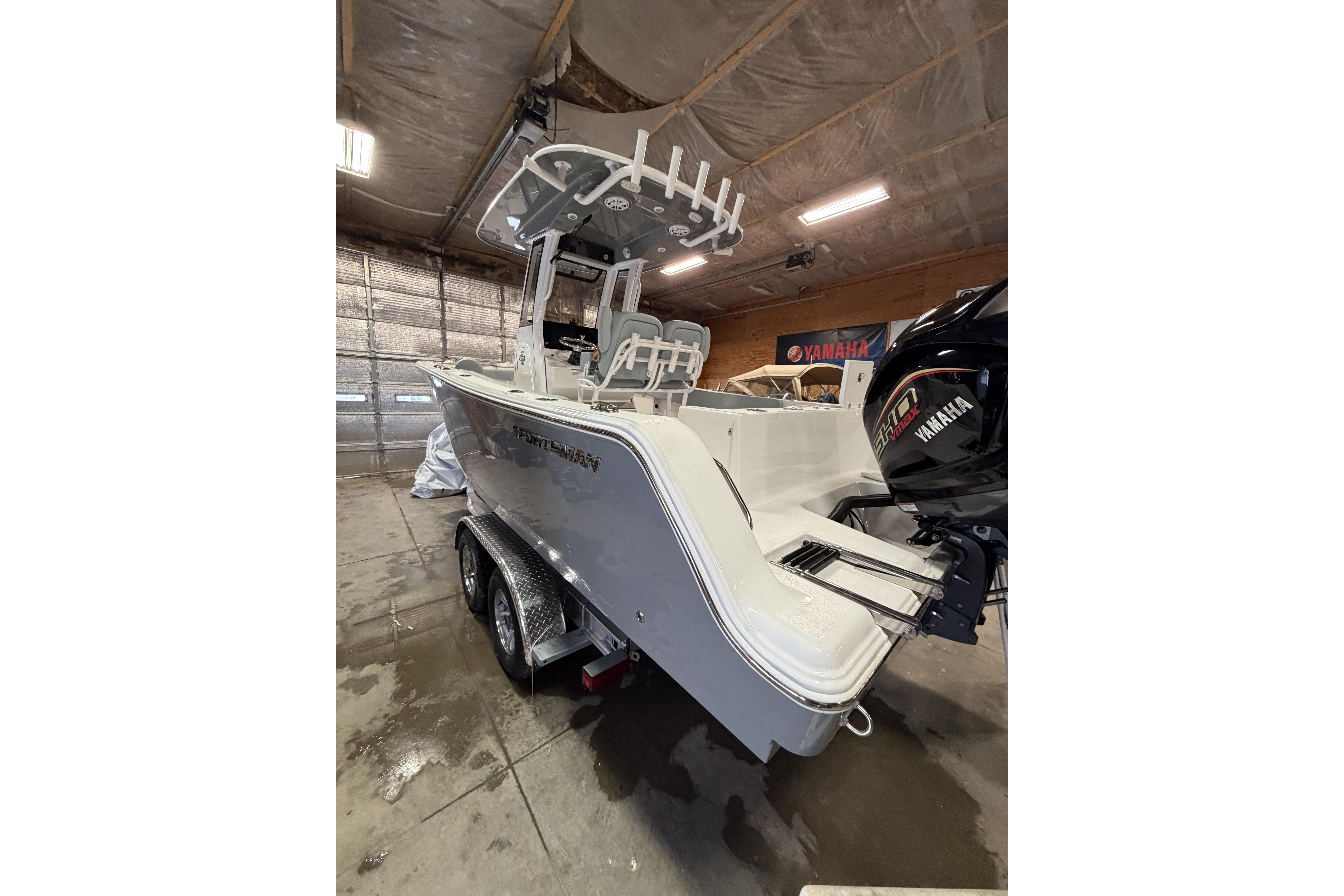 2026 Sportsman Open 232 Center Console boat in a garage with Yamaha engine.