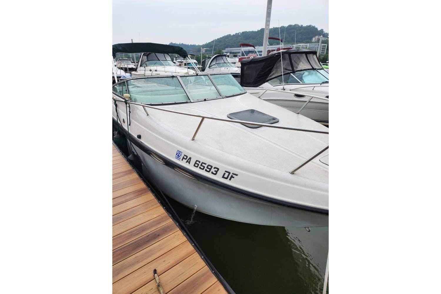 2001 Crownline 242 CR boat docked at marina, side view.