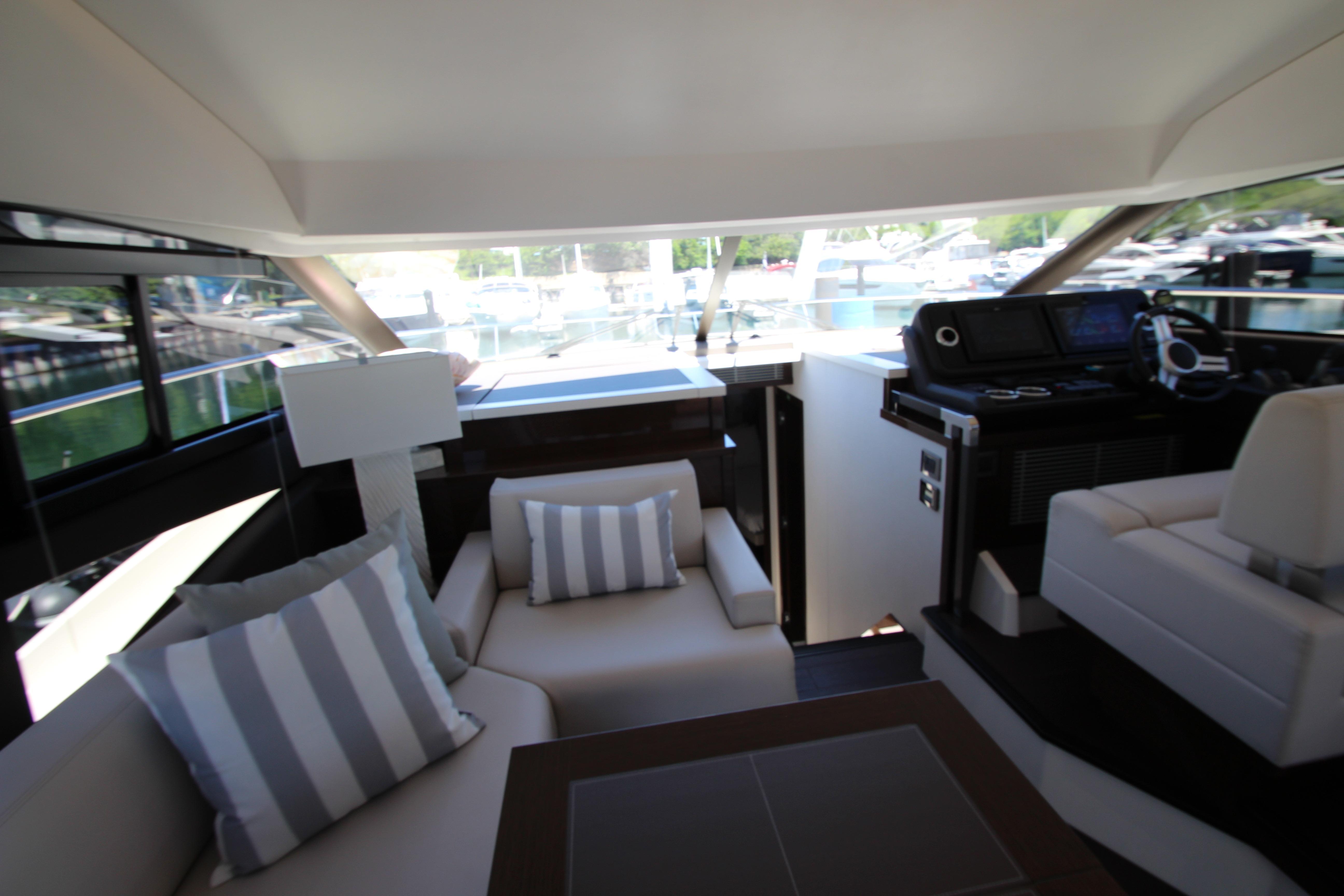 Luxurious interior of 2022 Prestige 520 yacht with plush seating and modern helm.