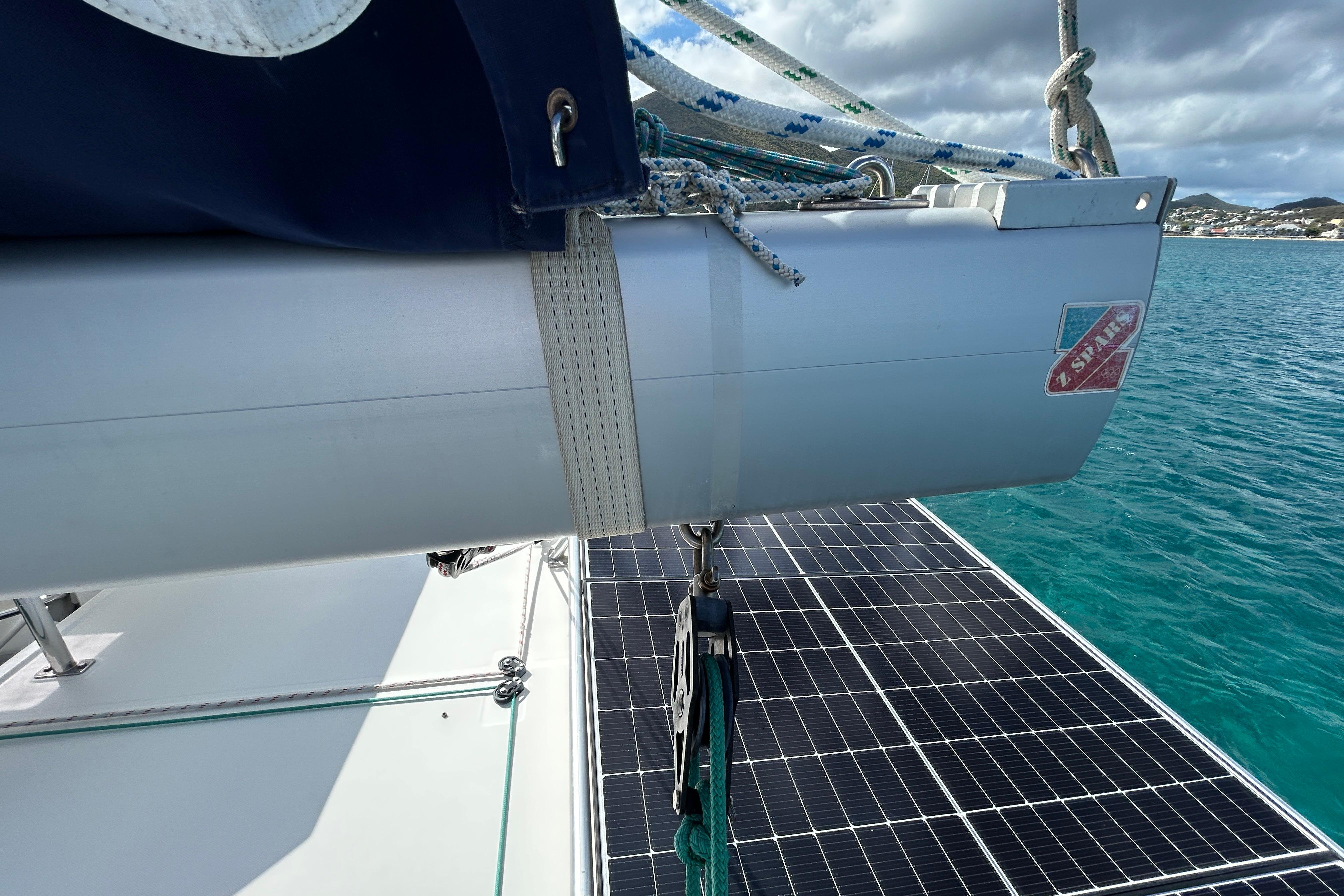 2020 Leopard 45 catamaran with solar panels and rigging, anchored in clear blue waters.
