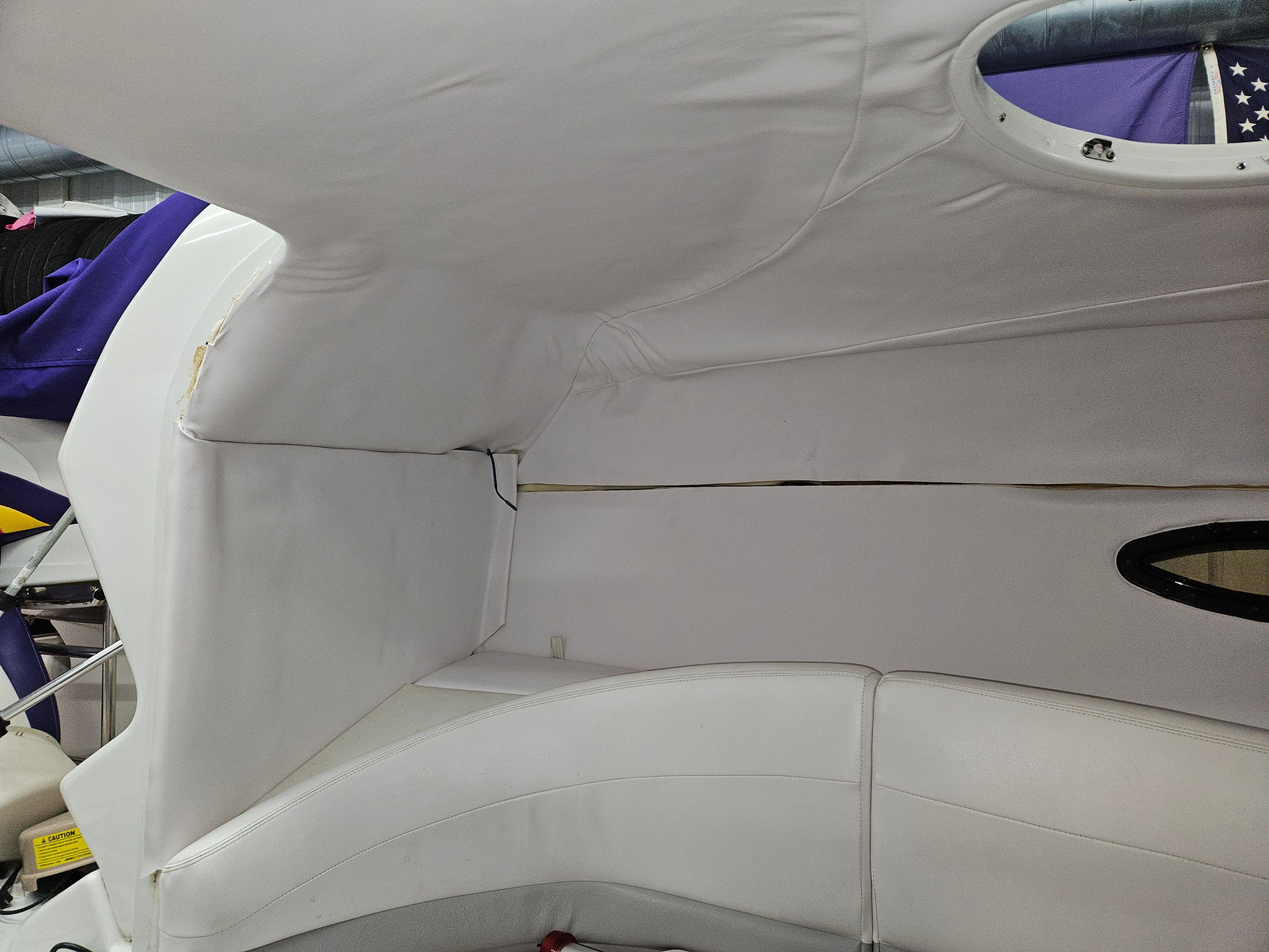 The image shows the interior of a 1996 Baja 302 Boss boat with white upholstery.