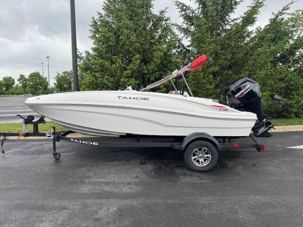 2025 Tahoe T16 boat on trailer, parked outdoors, with trees in the background.