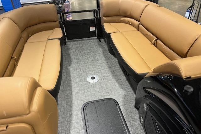Luxurious interior of 2026 Regency 230 DL pontoon boat with tan seating and gray flooring.