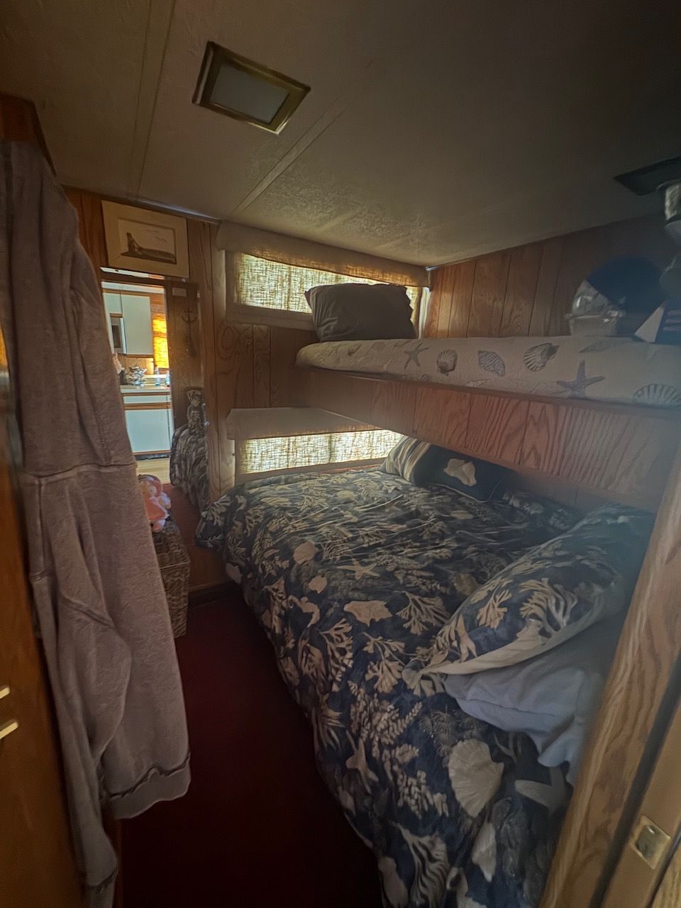 Interior of a Sumerset houseboat cabin with bunk beds and nautical-themed bedding.