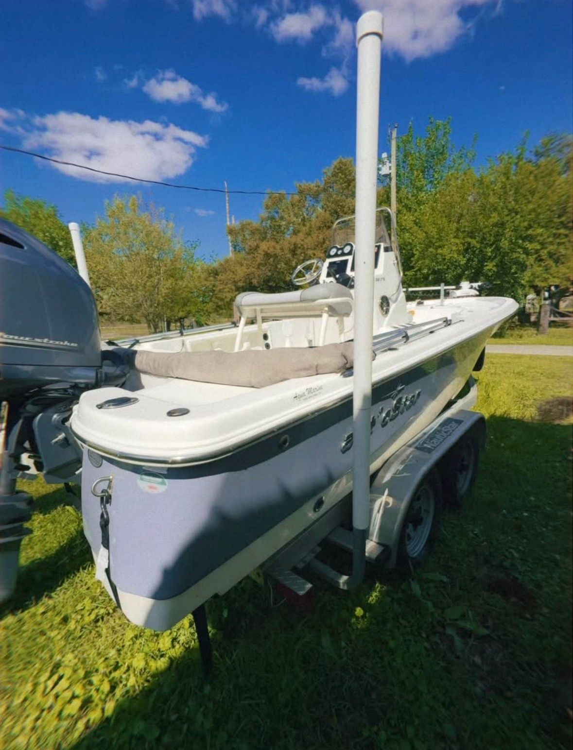 A 2022 Custom 215 XTS boat is on a trailer outdoors.
