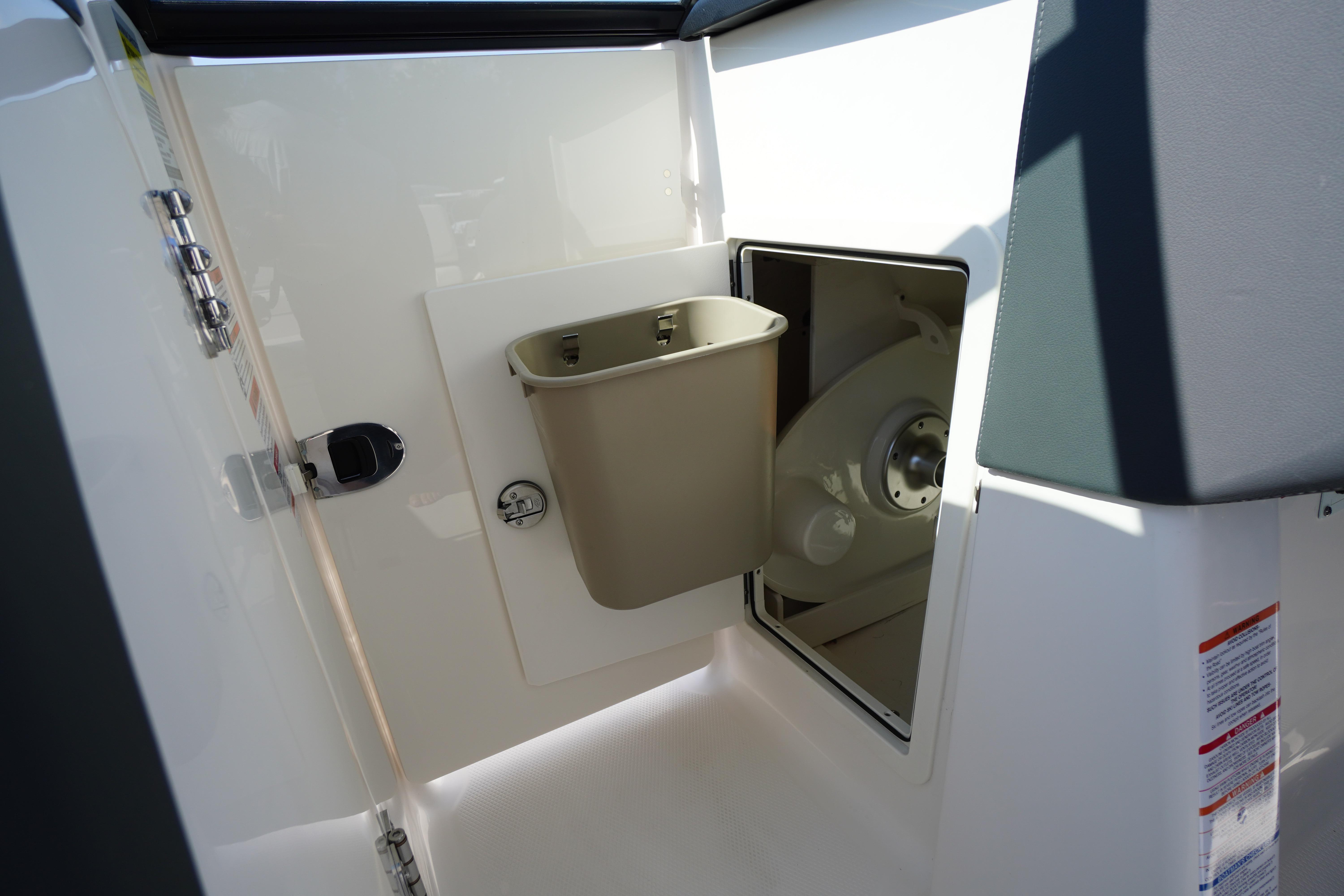 Interior storage compartment of 2026 Chaparral 270 OSX boat with trash bin.