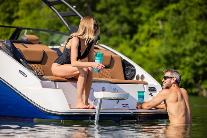 Couple enjoying leisure time on 2026 Yamaha Boats 222SE, relaxing by the water.
