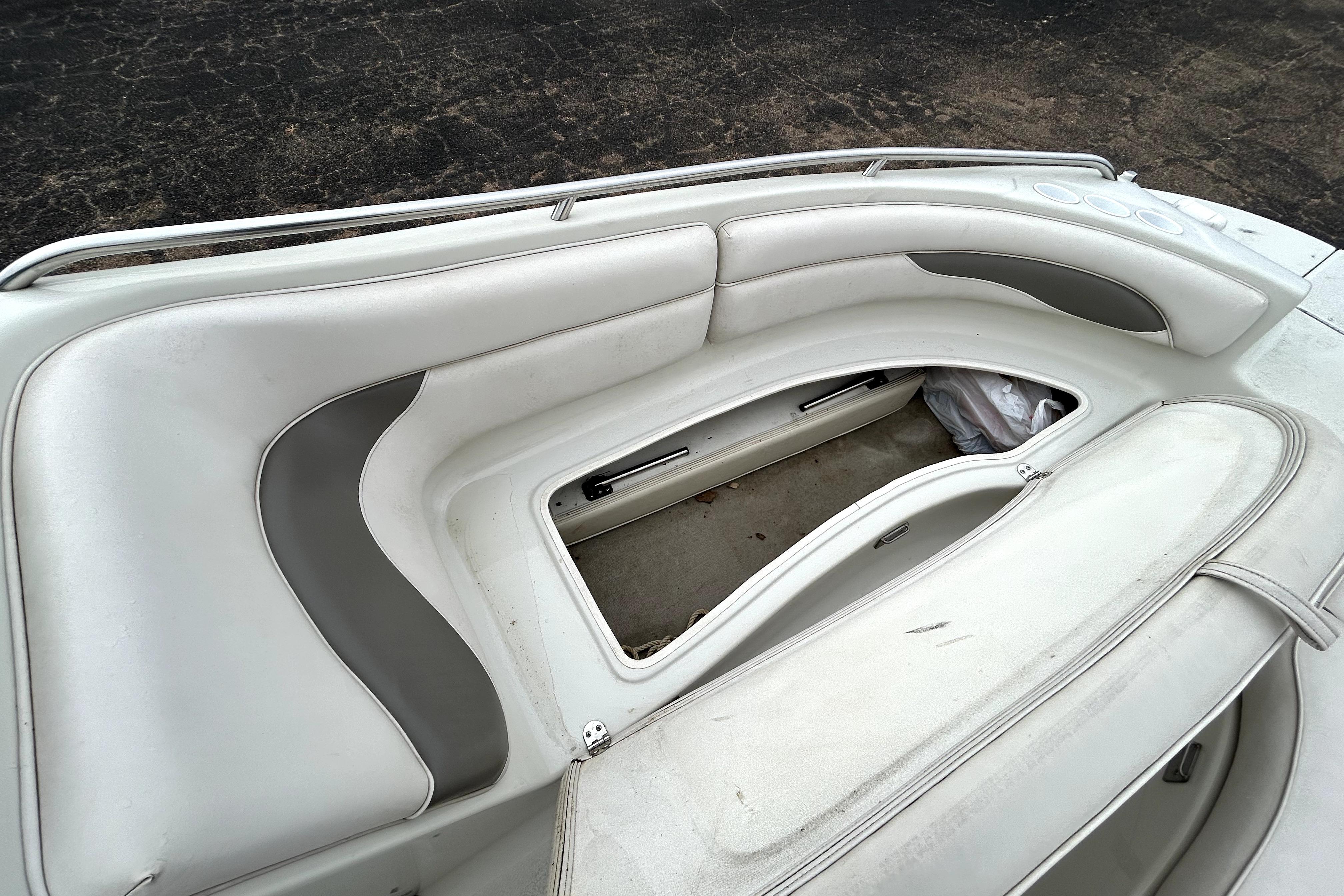 2001 Crownline 239 DB boat interior with white and gray seating and storage compartment.