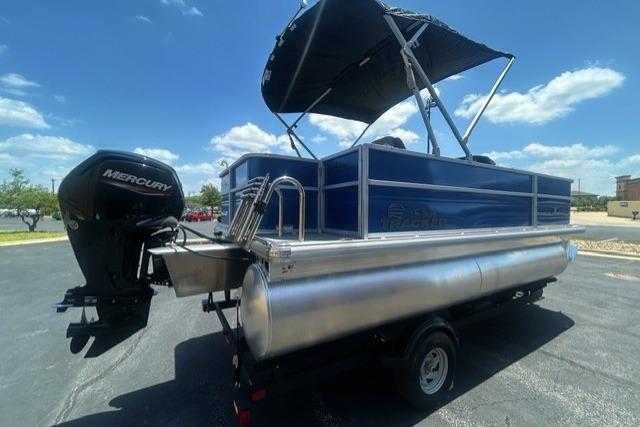 2026 Sun Tracker Party Barge 18 DLX pontoon boat with Mercury engine, parked outdoors.