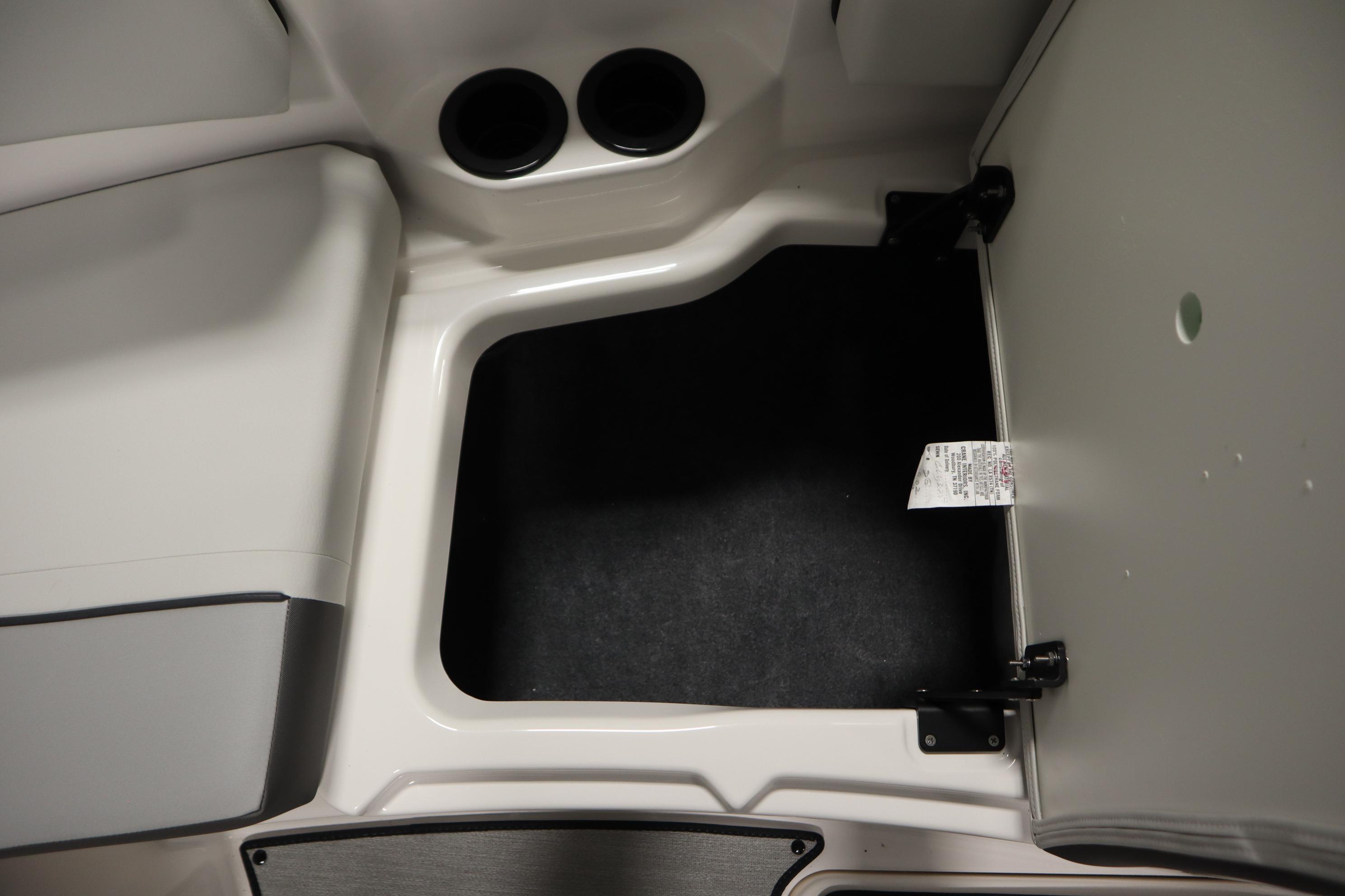 2026 Yamaha Boats AR220 storage compartment with cup holders and open hatch.