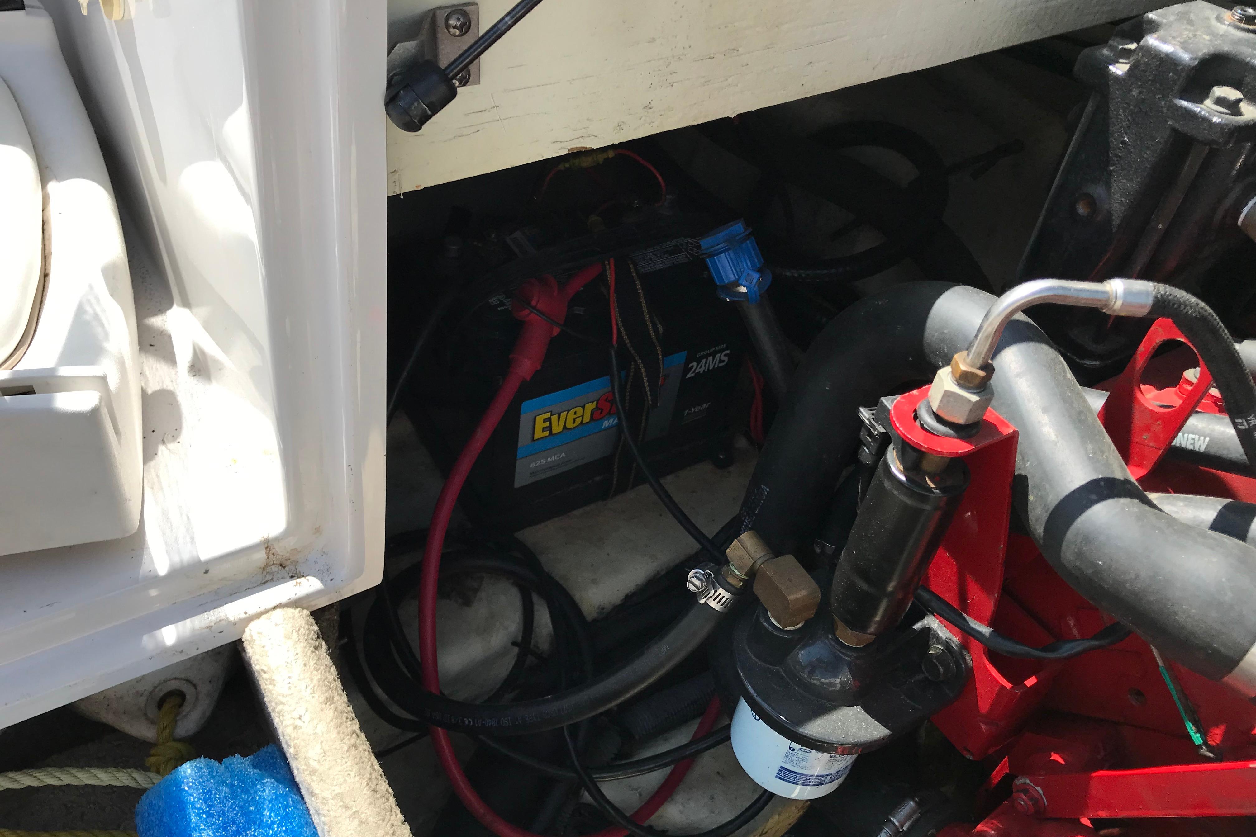 Engine compartment of a 2005 Four Winns 180 Horizon FS boat, showing battery and components.