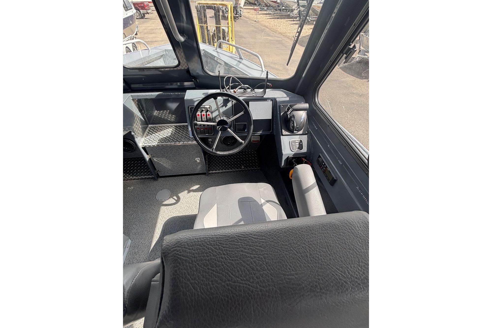 2024 Hewescraft 240 Ocean Pro Hardtop boat interior with steering wheel and controls.