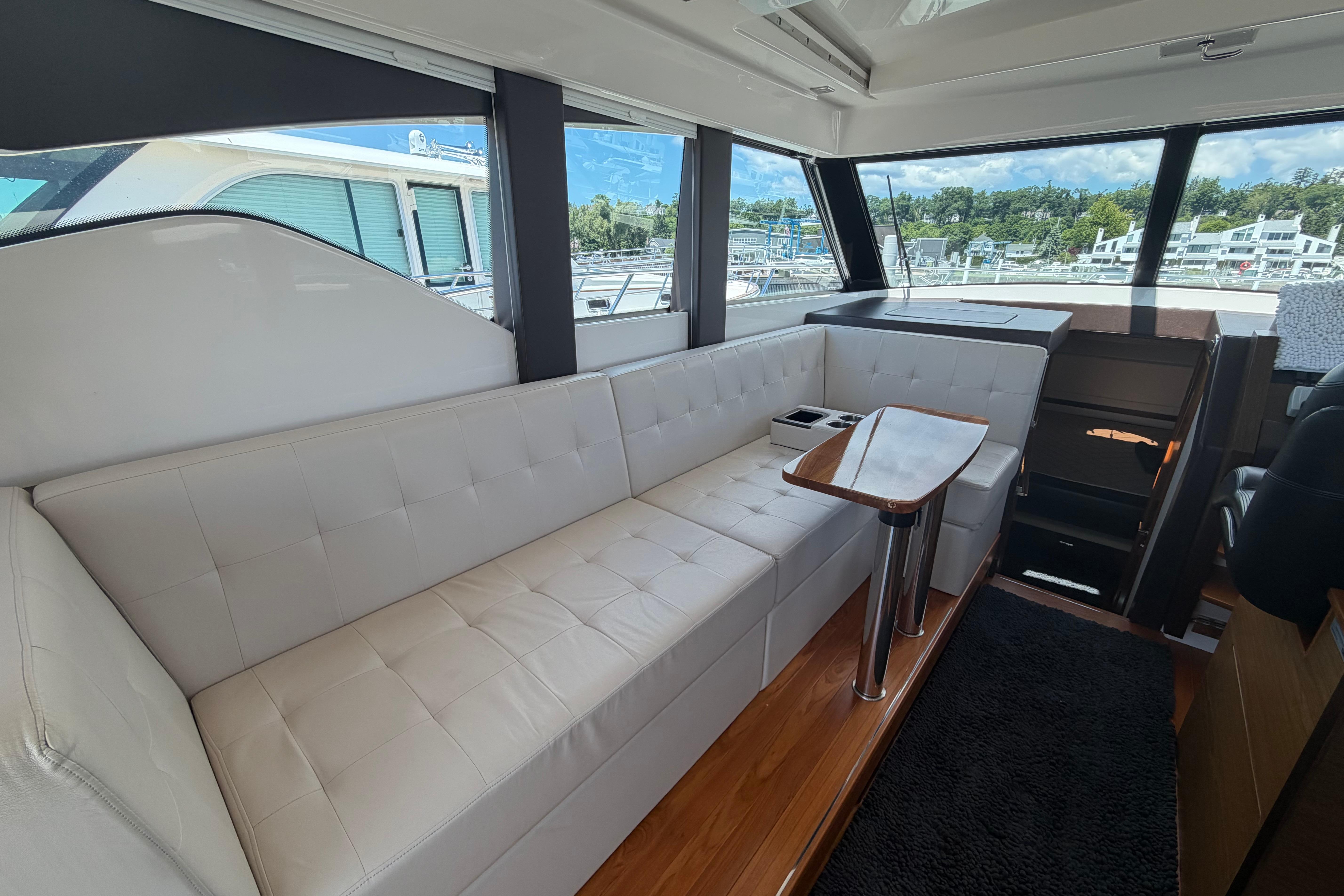 Luxurious interior of 2016 Tiara Yachts C39 Coupe with plush seating and elegant table.