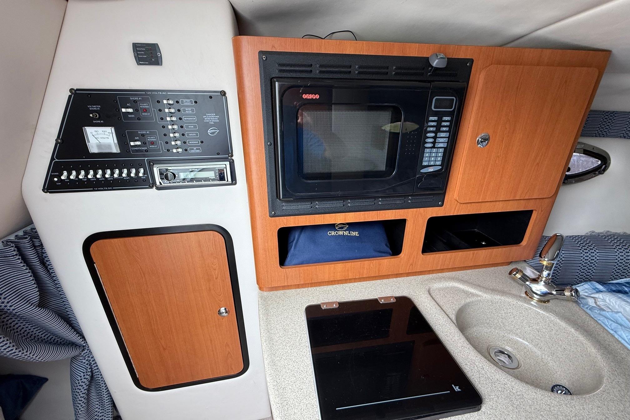 2005 Crownline 250 CR cabin interior with microwave, sink, and control panel.