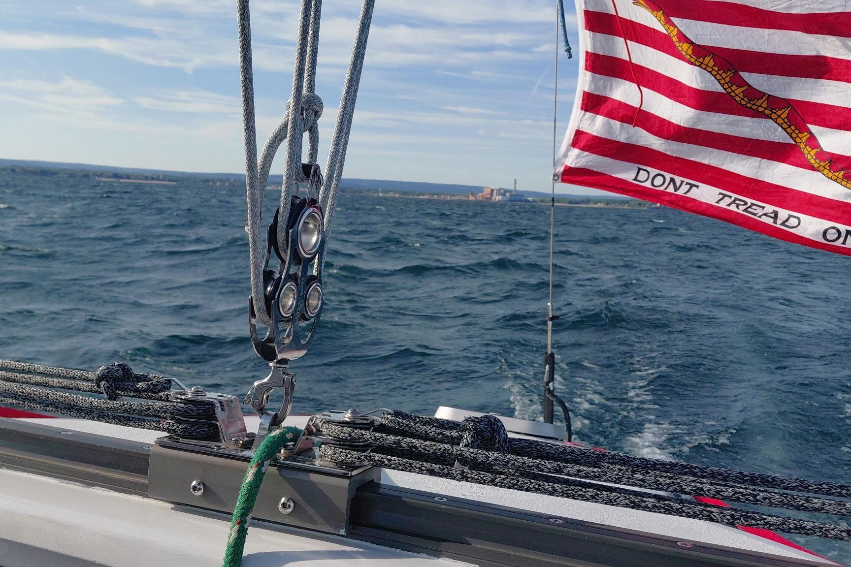 Sailing on a 1979 Newick Native boat with "Don't Tread On Me" flag in the wind.