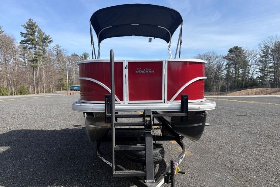 2026 Sun Tracker Party Barge 18 DLX pontoon boat on trailer, parked outdoors.