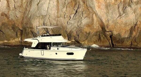 2021 Beneteau Swift Trawler 35 near rocky coastline.