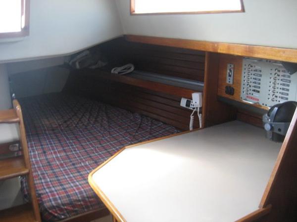 Interior of a 1984 C&C Landfall with a bed and navigation area.