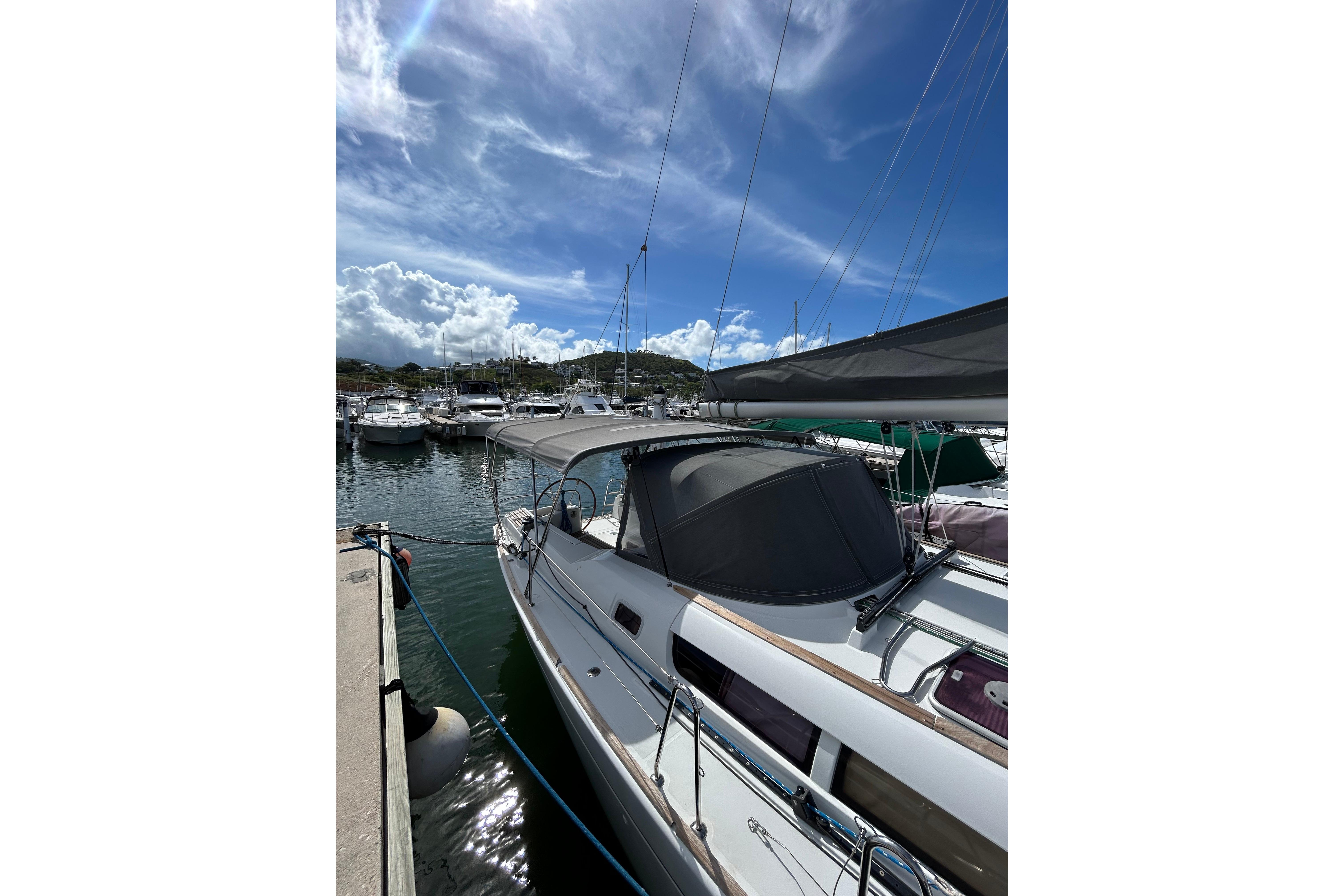 2011 Jeanneau Sun Odyssey 44i sailboat docked at marina under blue sky.