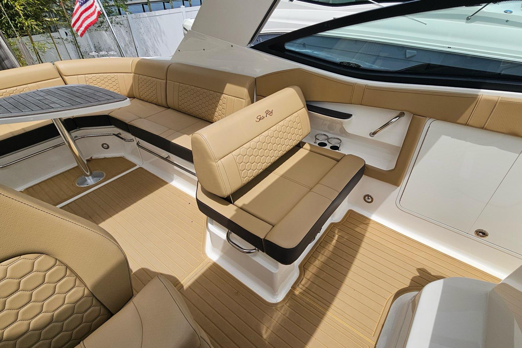 Luxurious interior of 2023 Sea Ray Sundancer 320 with tan seating and table.