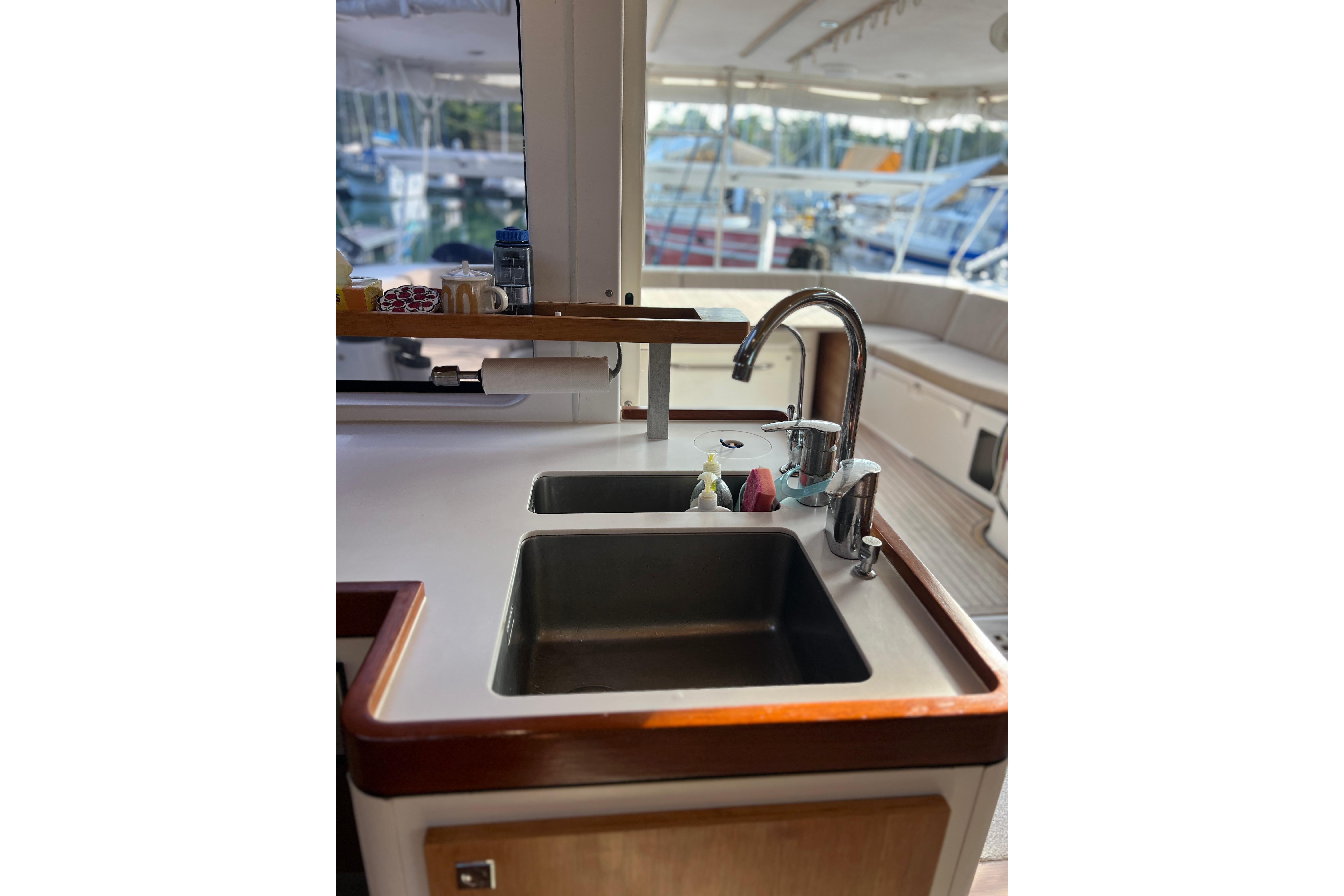 Galley sink area on 2015 Outremer 51 catamaran, featuring modern fixtures and marina view.