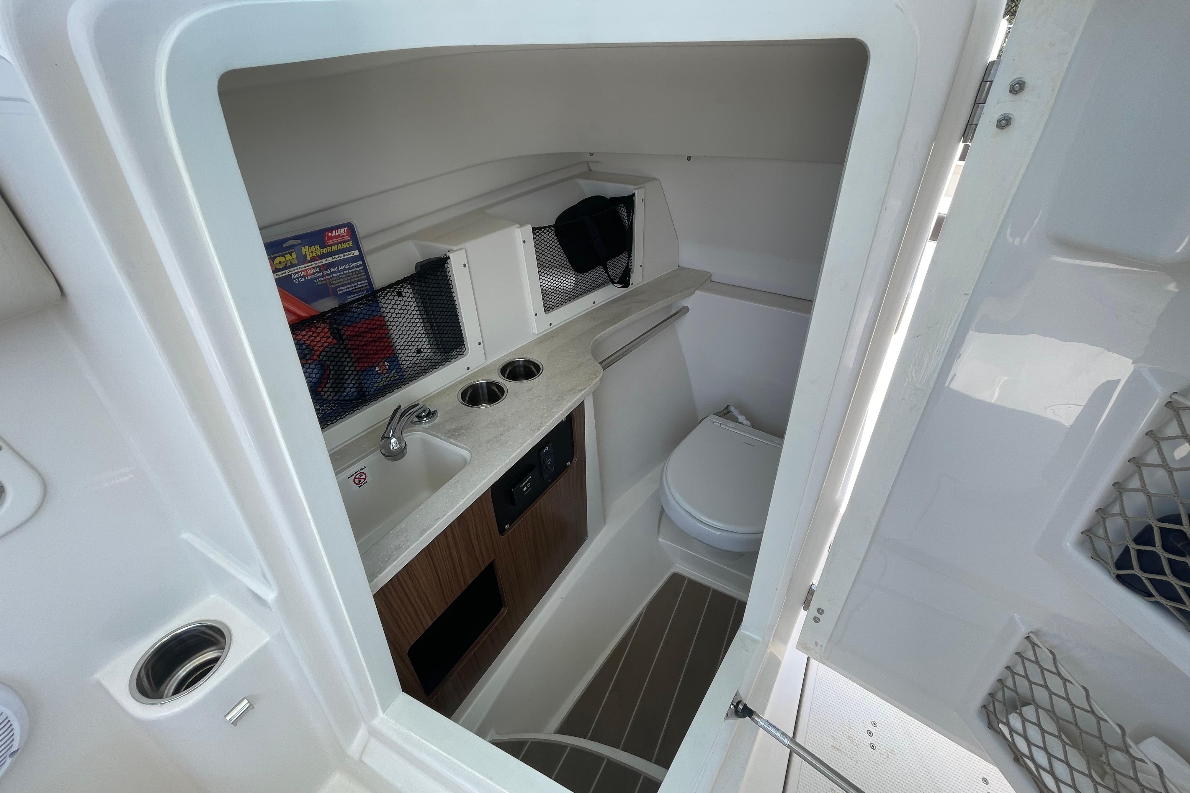 2022 Sailfish 245 DC boat interior with compact bathroom and sink area.