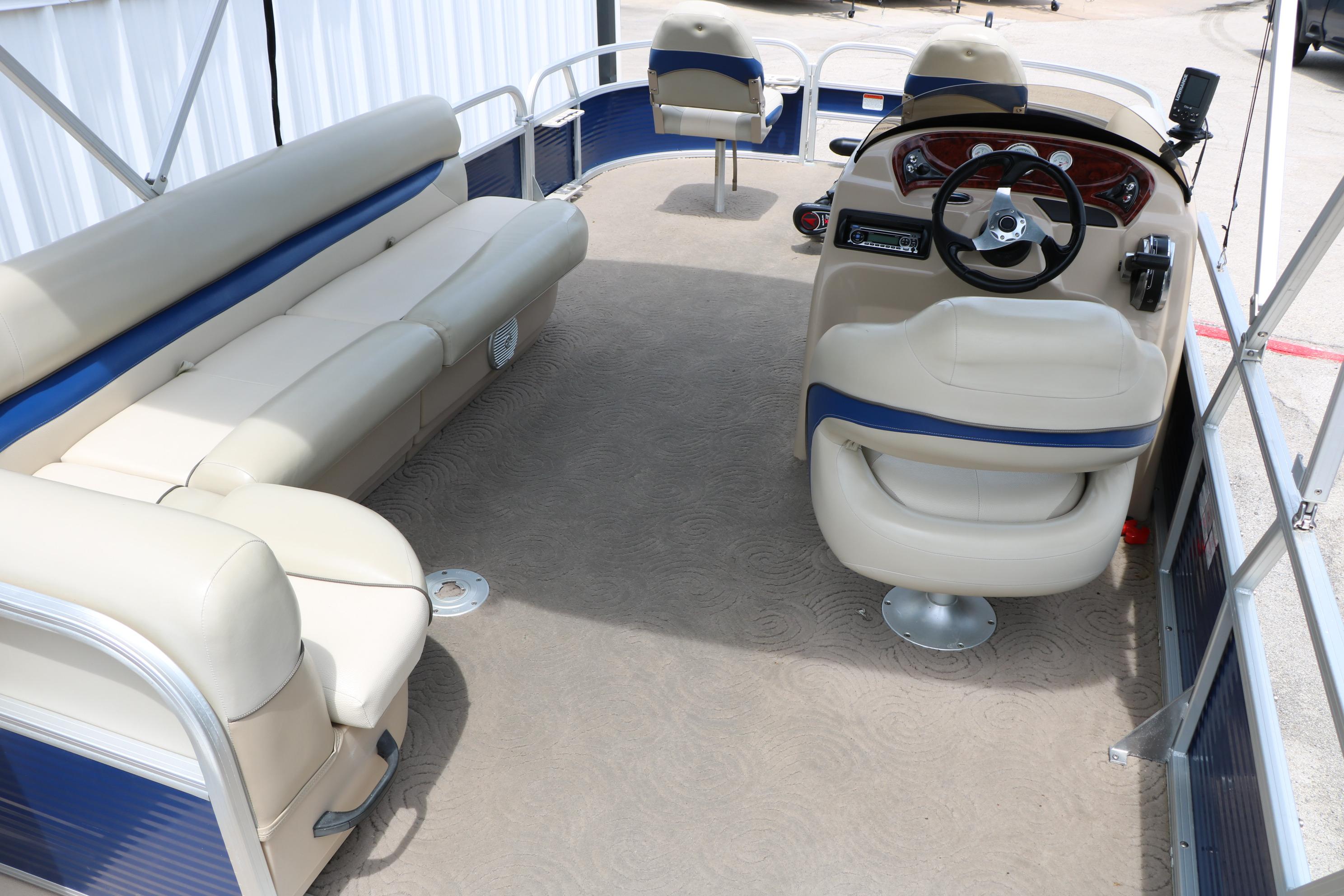 2013 Sun Tracker Fishin' Barge 20 DLX interior with beige seating and steering console.