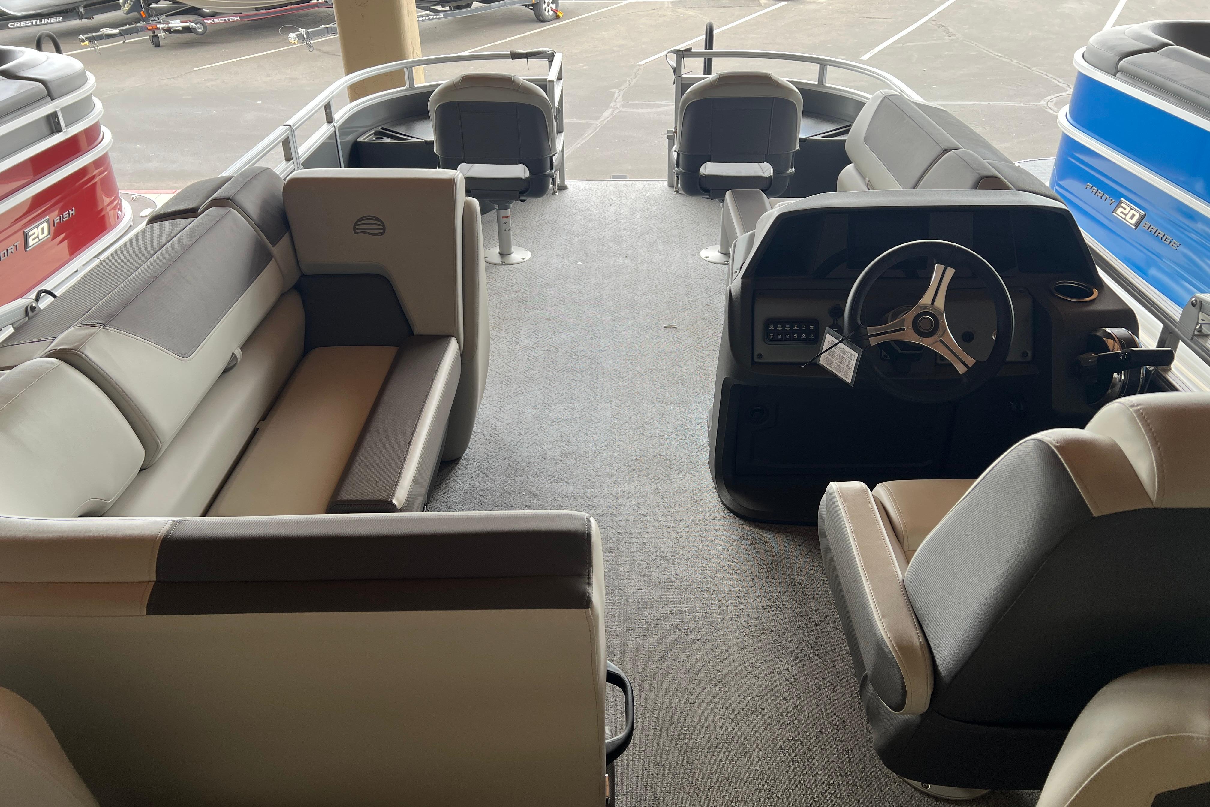 Interior view of 2026 Sun Tracker Fishin' Barge 20 DLX pontoon boat with seating and helm.