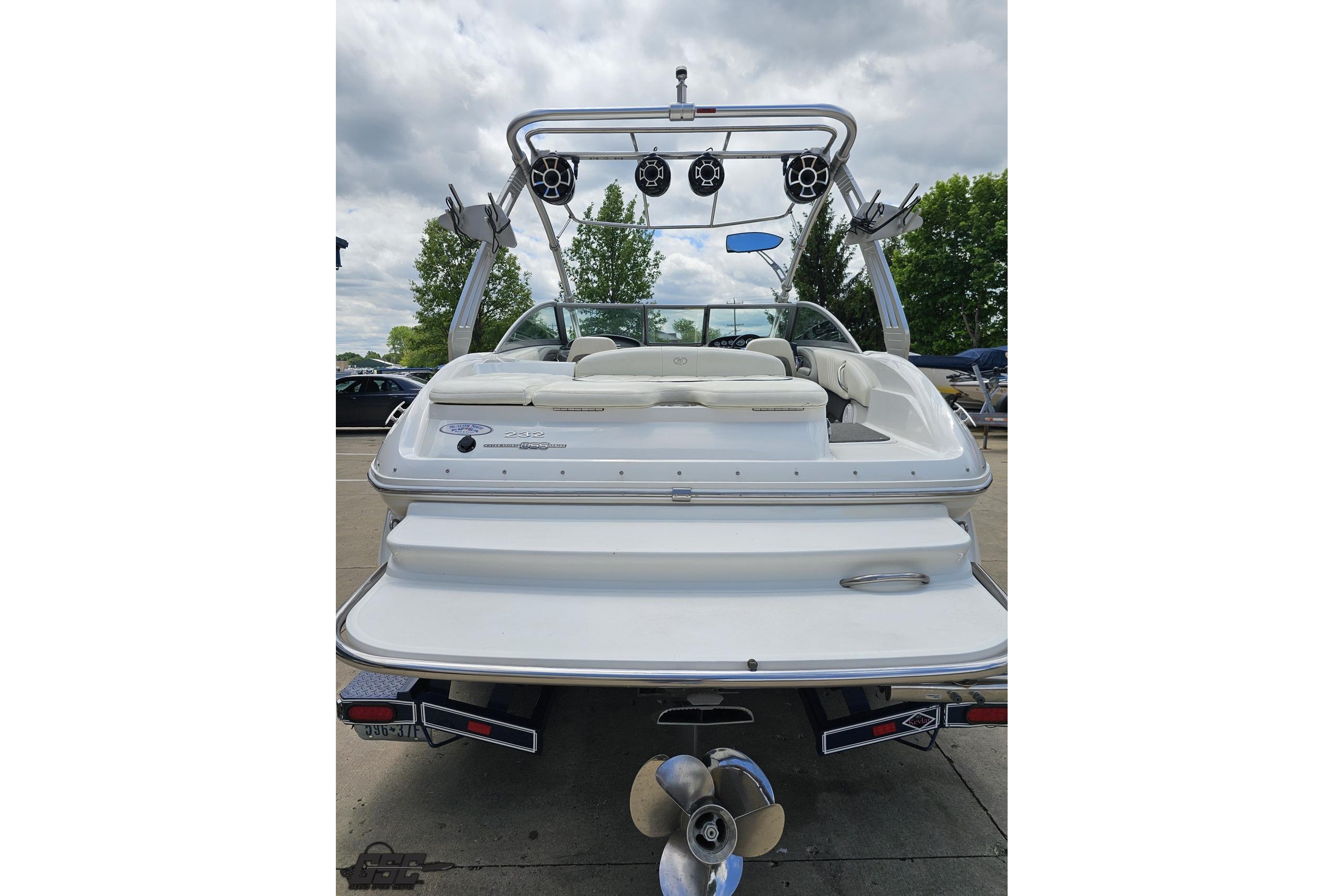 2010 Cobalt 232 WSS boat, rear view with speakers and seating, parked outdoors.