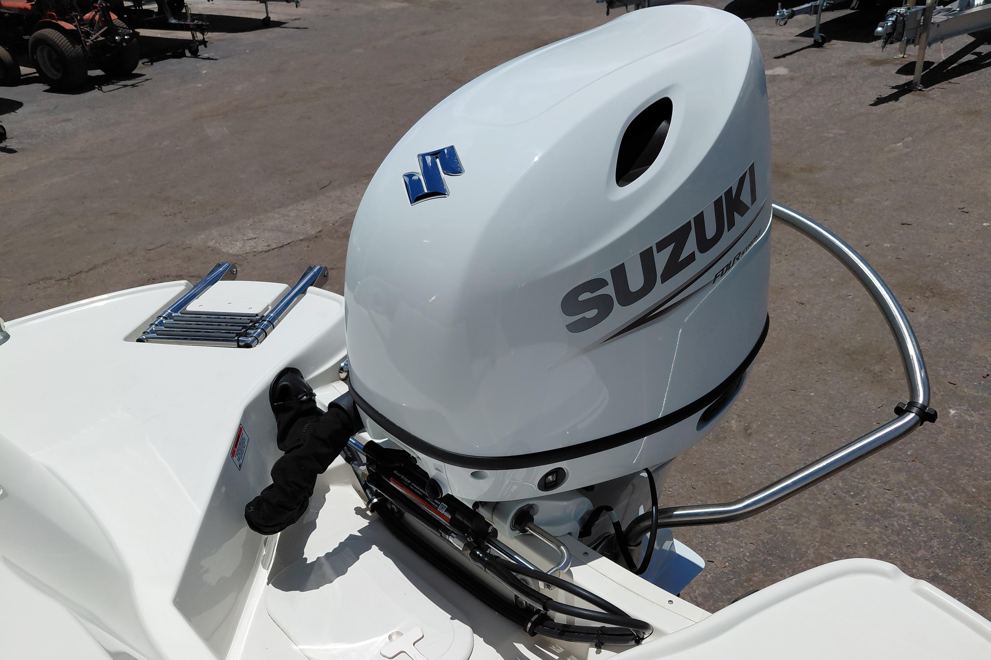 2023 Stingray 206 CC boat with Suzuki outboard motor, parked on a sunny day.