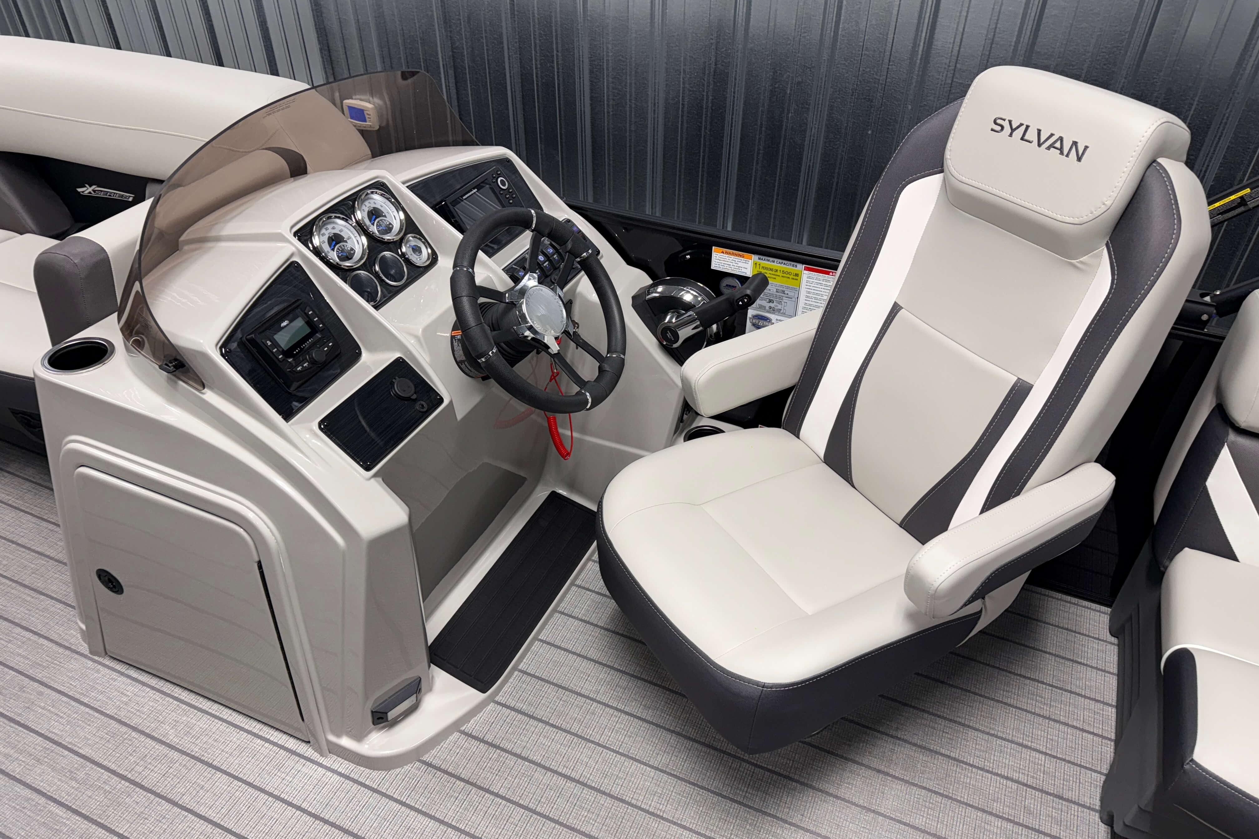 2026 Sylvan Mirage X1 boat cockpit with steering wheel and captain's chair.