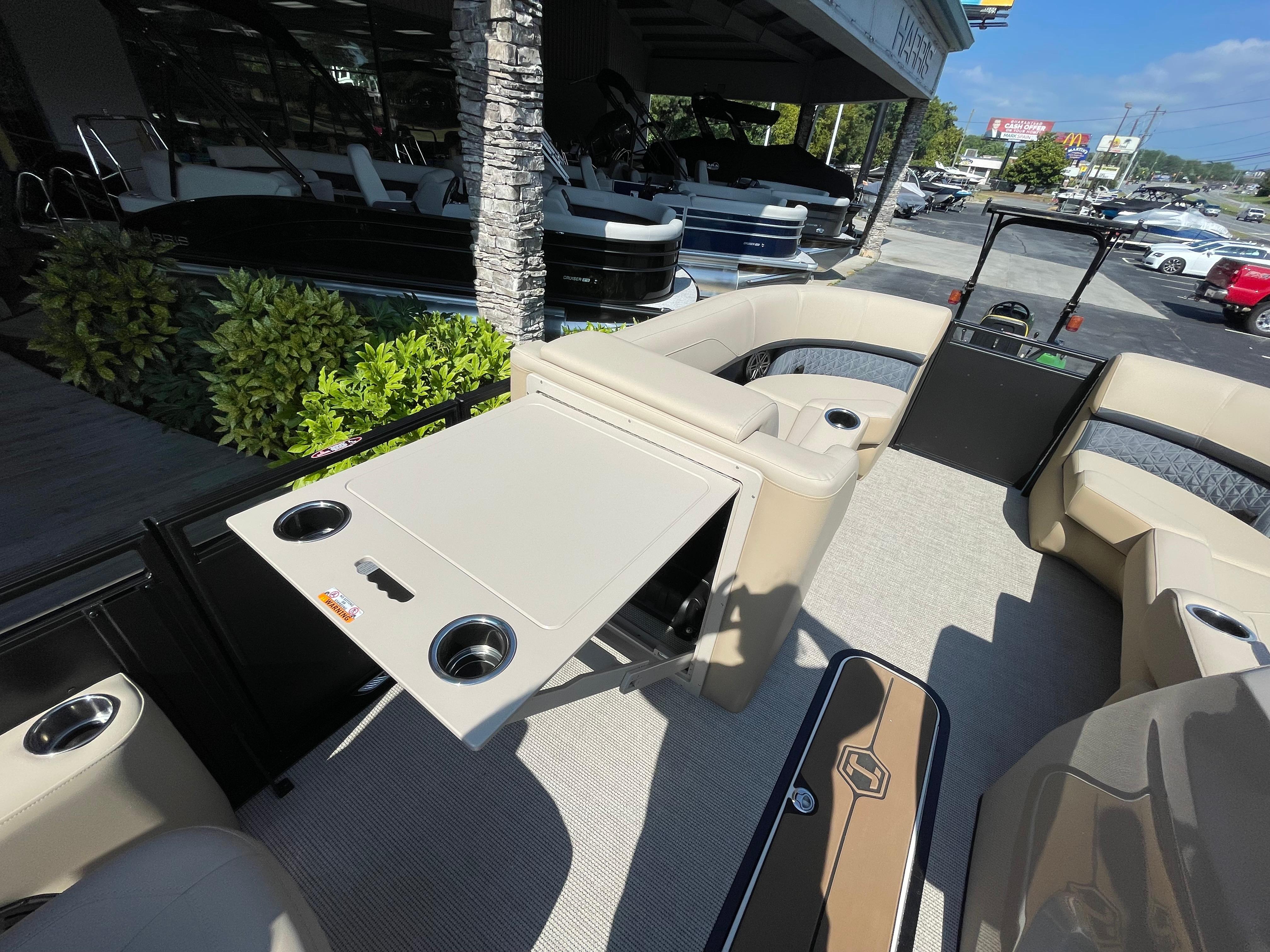2026 Harris Solstice 230 pontoon boat interior with beige seating and foldable table.