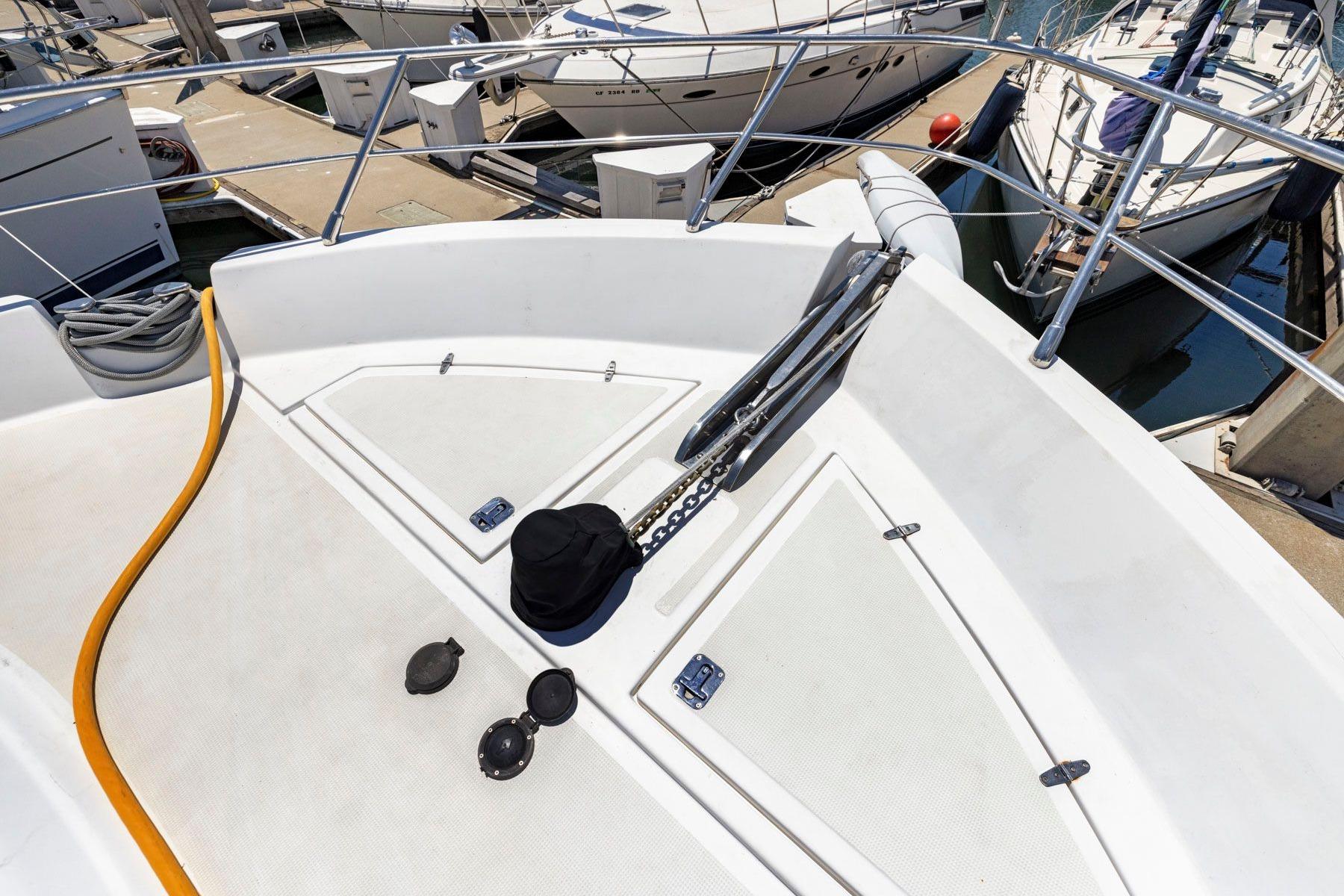 Bow of a 1999 Symbol 55 yacht docked at a marina with visible equipment.